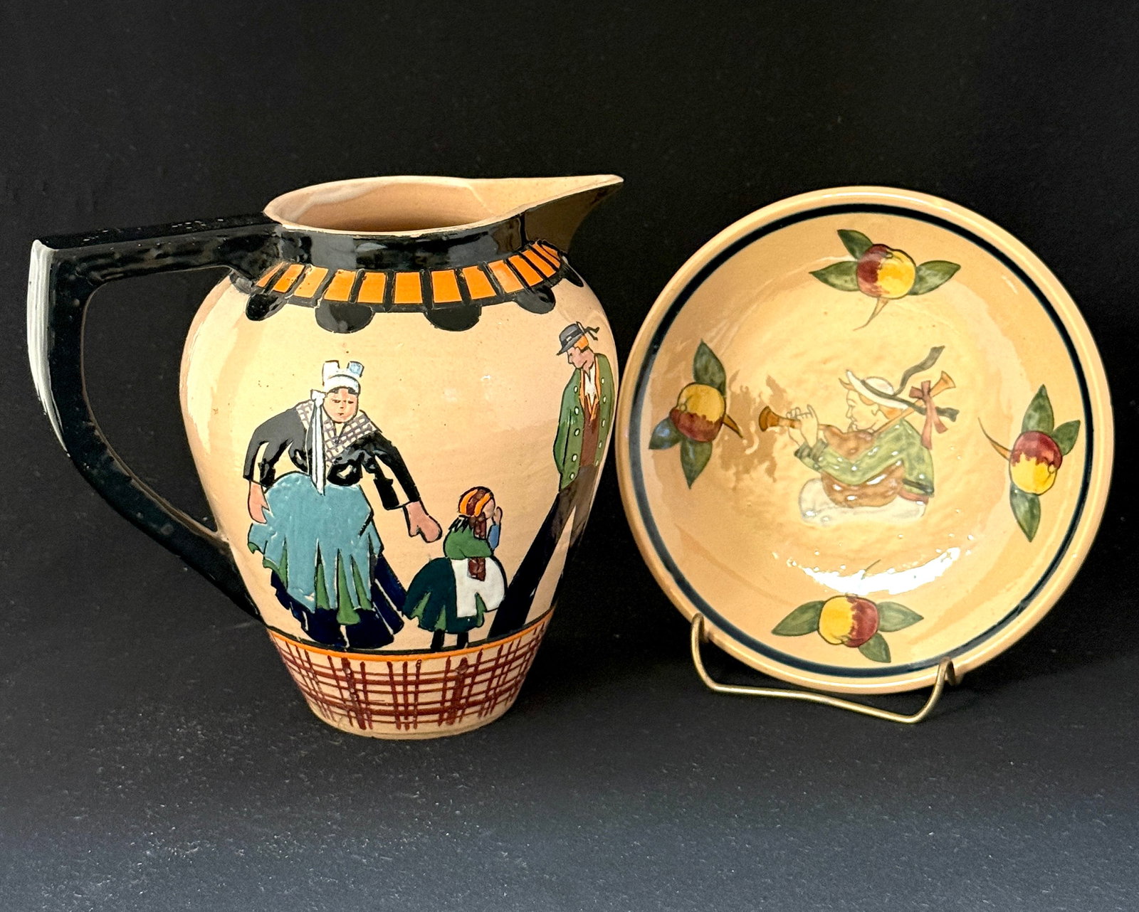 2 HenRiot Quimper Items: 2 HenRiot Quimper items a JE Svellec art deco pitcher with a C. Maillard underplate. Pitcher decorated with Breton mother, father, and young daughter on both sides. Underplate decorated with Breton