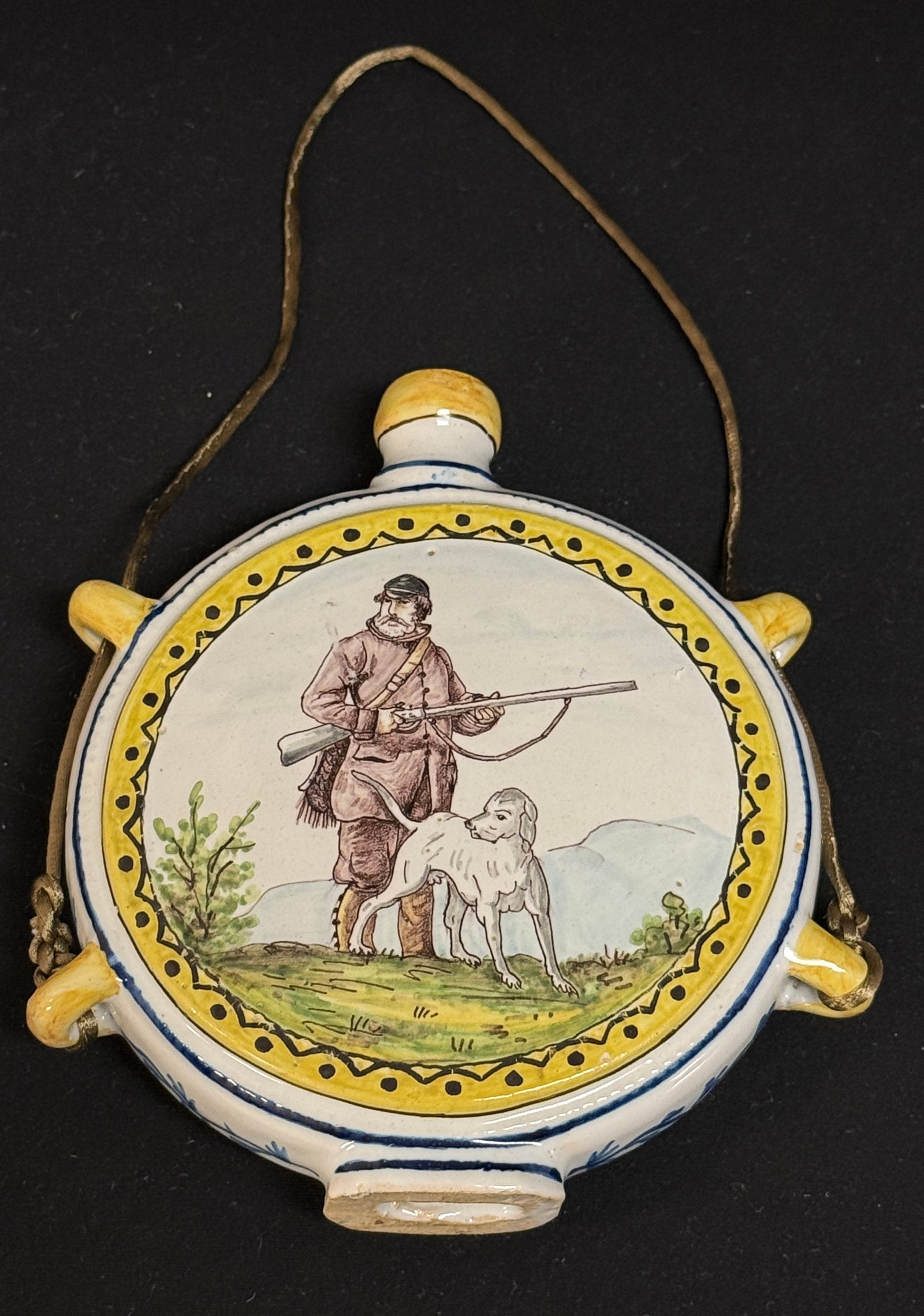 HB Gourde/Flask: HB gourde/flask with sporting scene of a hunter and his dog, has loops for hanging; ht 6 3/8" circa 1860-1870. CONDITION: Quimper has propensity to have minor chips, glaze loss/wear and crazing.