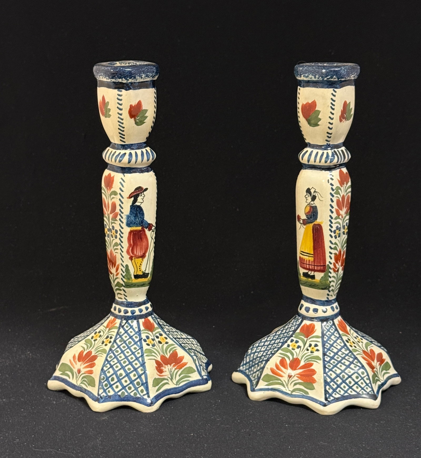 Pr HenRiot Quimper Candlesticks: Pr HenRiot Quimper candlesticks with a Breton couple along with sponging, cross hatching, and floral sprays; ht. 8 1/2" circa 1930-1950. CONDITION: Quimper has propensity to have minor chips, glaze