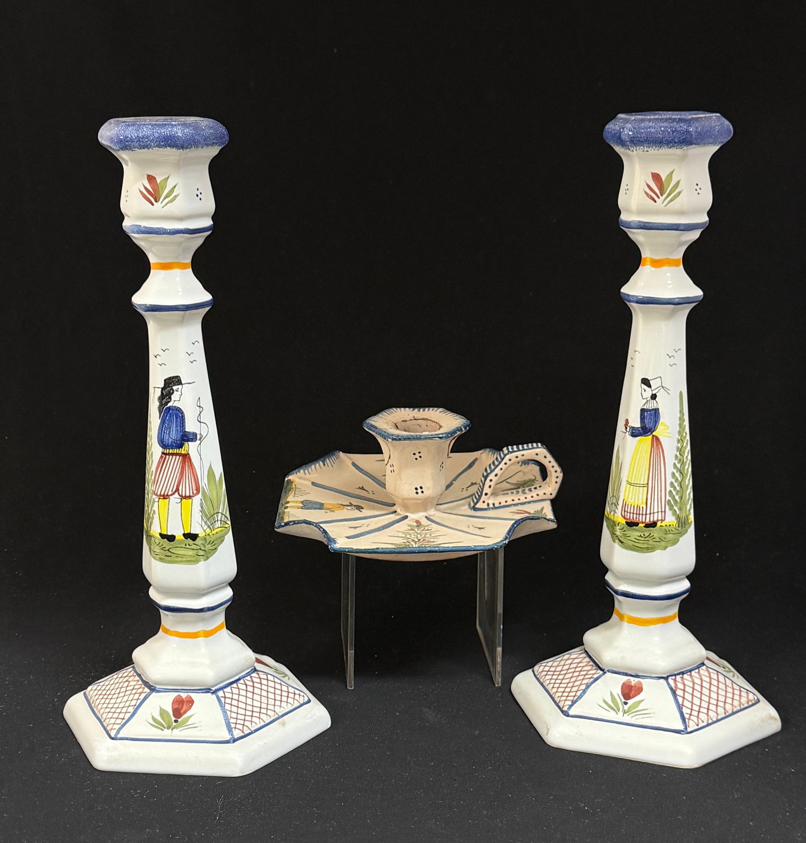 HB HenRiot Quimper Candlesticks: 3 HB HenRiot Quimper candlesticks, 2 tall with Breton couple and an HB candle stand with Breton; tallest ht. 11 1/4" circa 1883-1904. CONDITION: candle stand has been repaired. Quimper has propensity 