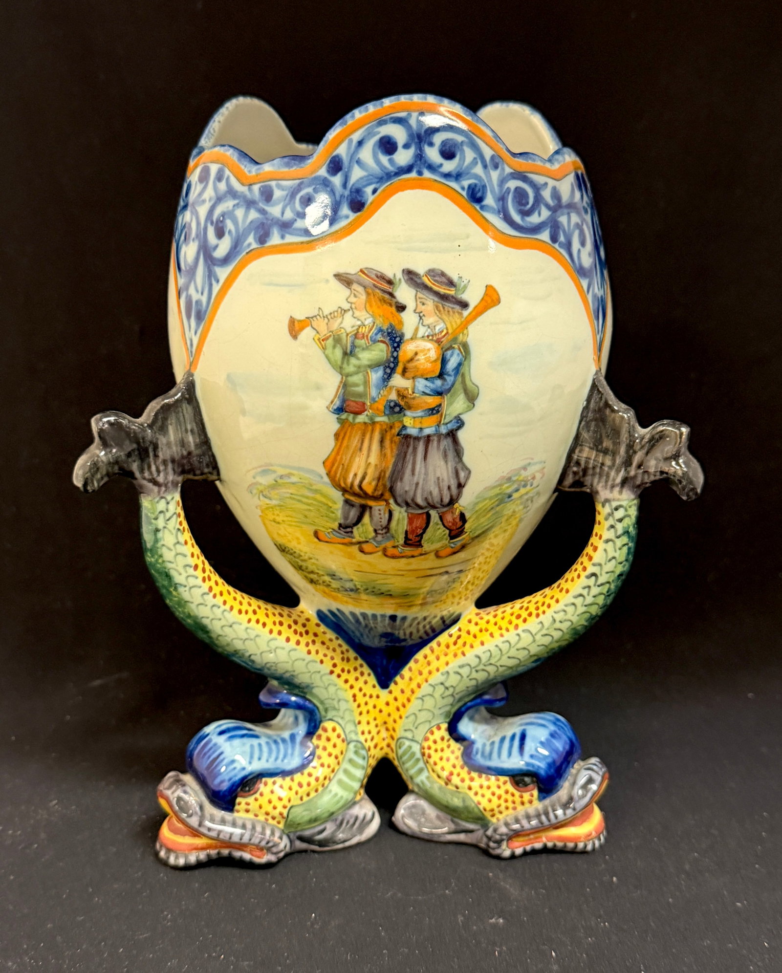 HR Quimper Egg Shaped Vase: HR Quimper egg shaped vase supported by 3 dolphin feet and with panels of floral sprays, Blason of Quimper, and Bretons playing a biniou and bombarde, glazed in soft used on Porquier Beau pieces. Exce