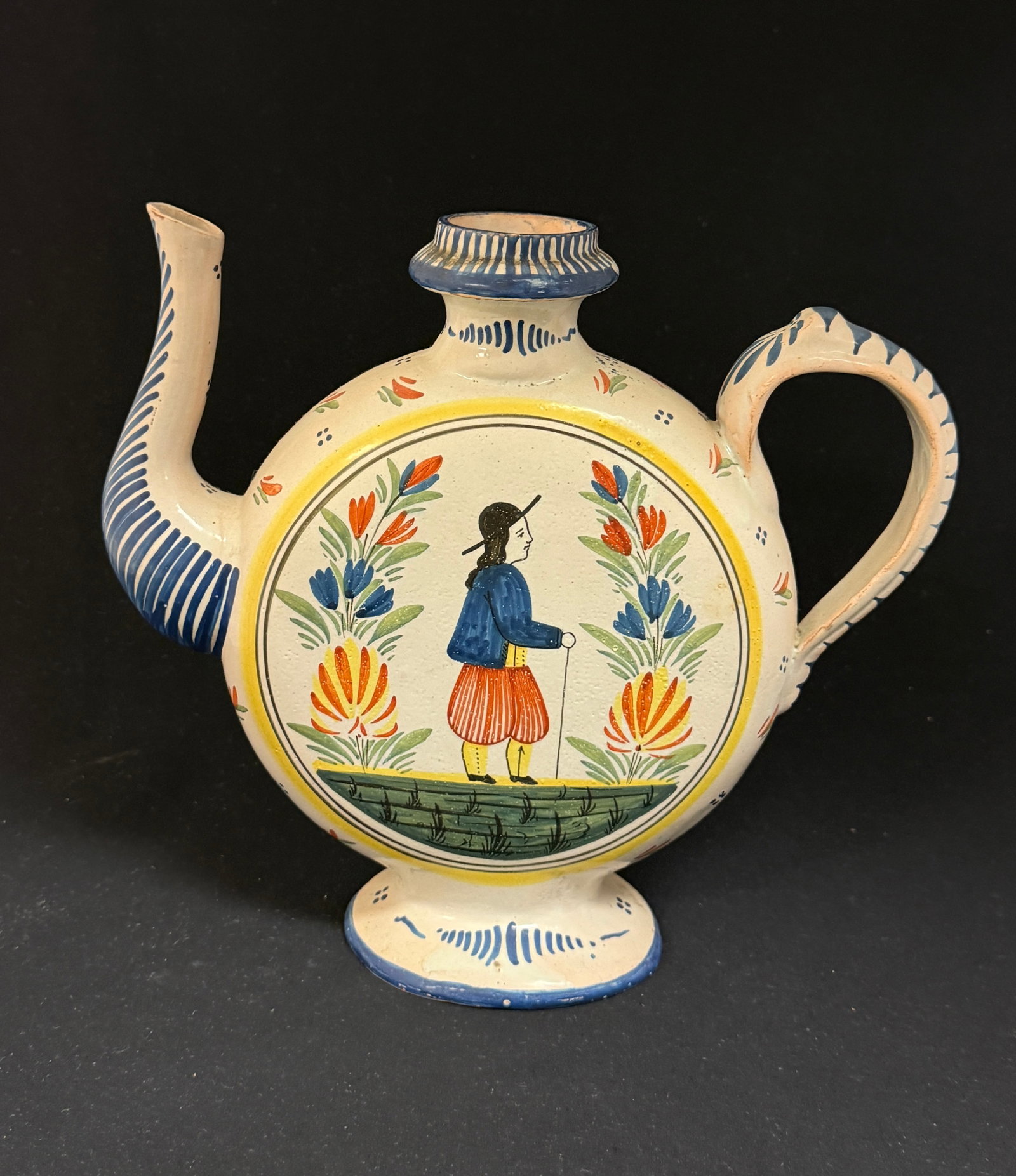 HB Quimper Teapot: HB Quimper moon flask form tea pot with Breton and Bretonne figures flanked by a la touch floral sprays and 4 dot motif, one on each side; ht. 9" circa 1900. CONDITION: missing lid. Quimper has propen