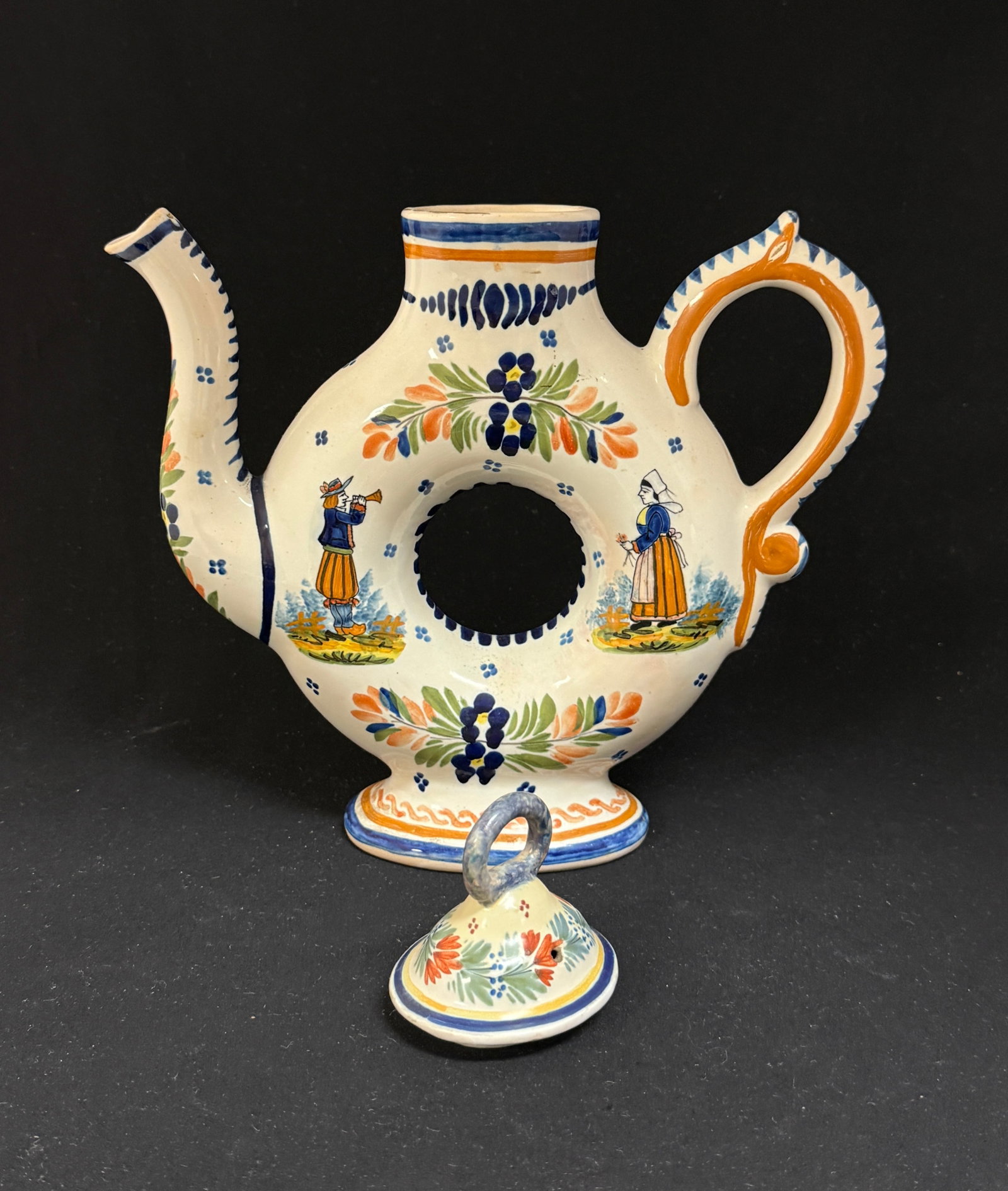 HenRiot Quimper Donut Teapot: HenRiot Quimper donut teapot with associated lid that does not fit, Breton and Bretonne figures, four dot motif and a la touch? floral and foliate sprays on body and spout; ht. 8 1/2" circa