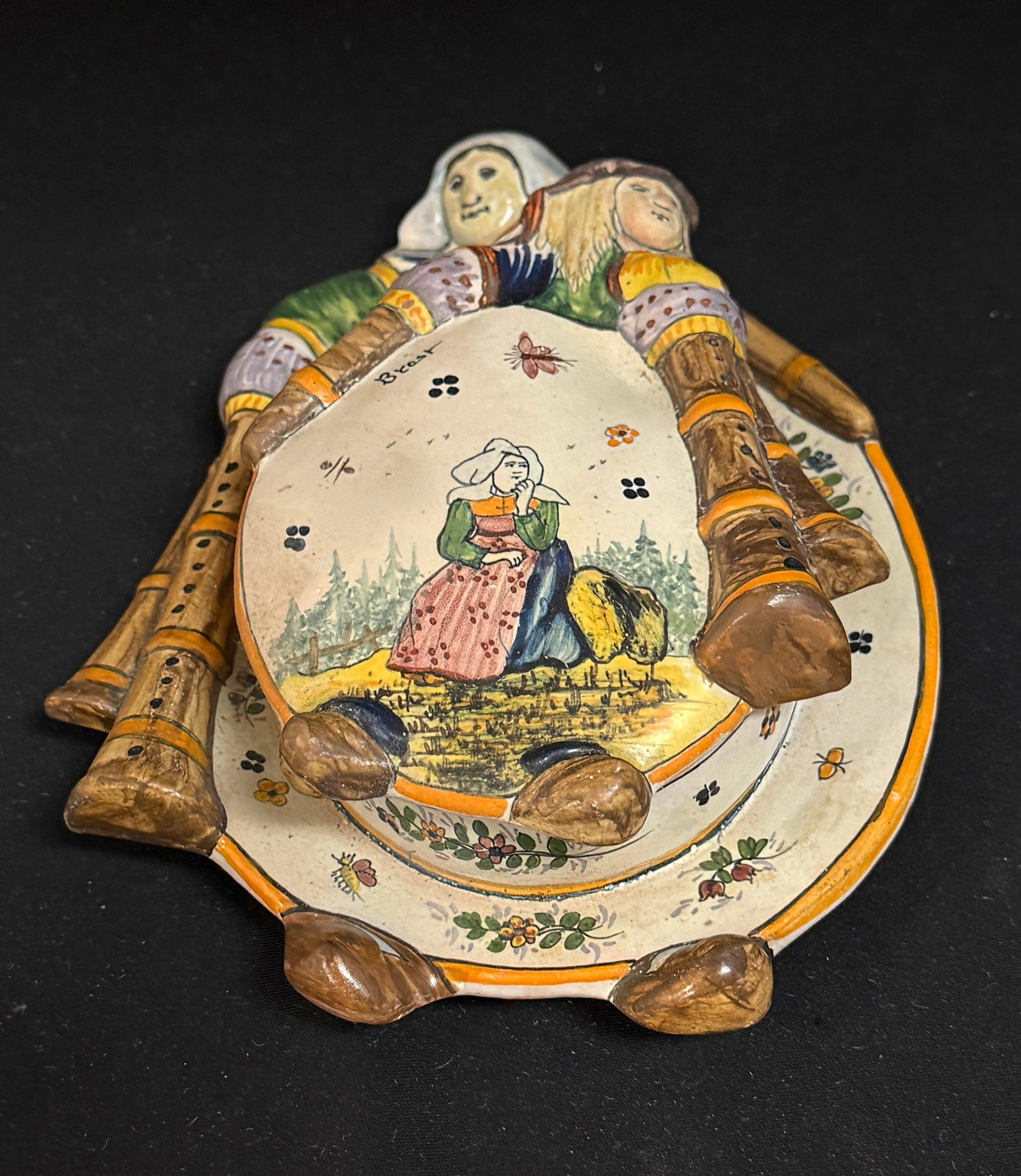 LeRoy Dubois Malicorne Butter: LeRoy Dubois Malicorne intricately formed lid features a Beton atop a biniou and a seated Bretonne is gazing into the distance as a butterfly floats by marked Brest, the biniou shaped base depicts a B