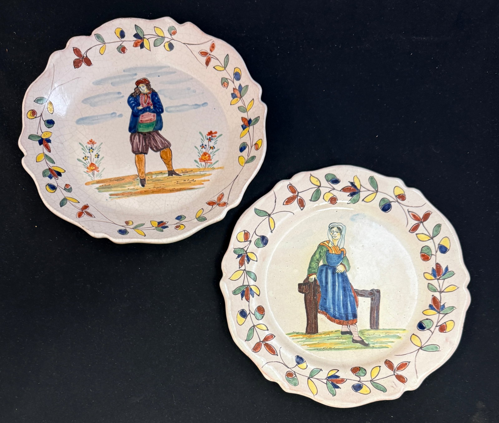 2 Malicorne Plates: 2 Malicorne plates, 1 deep plate with young Breton with folded arms, the other plate has Bretonne resting on fence both with traditional Malicorne borders; diameter 9 3/4" circa 1895-1920. CONDITION: