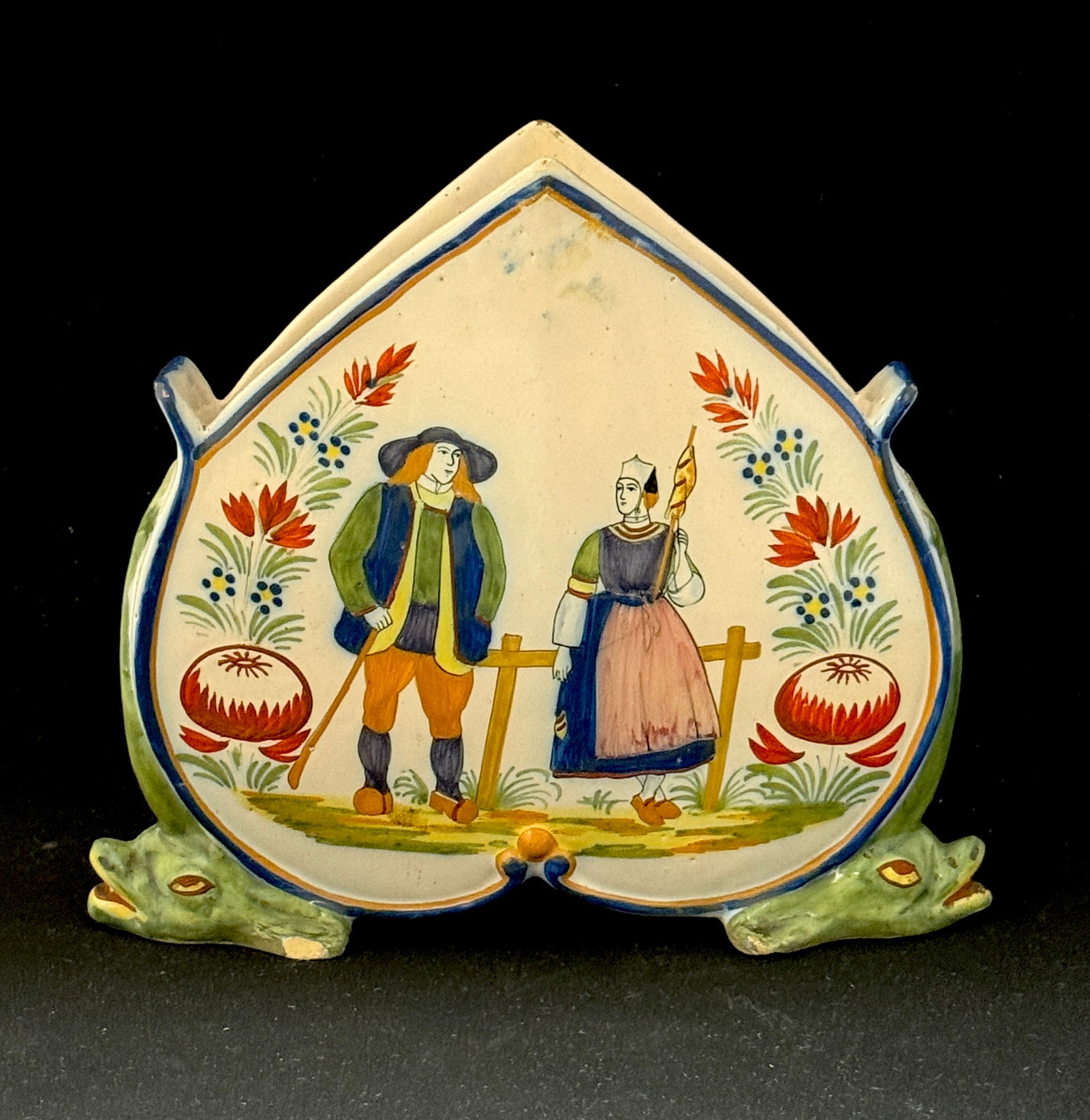 HenRiot Quimper Jardiniere: HenRiot Quimper inverted heart jardiniere with dolphin feet, front panel decorated with Breton couple with walking stick and staff in front of a rail fence, the back panel decorated with basket of