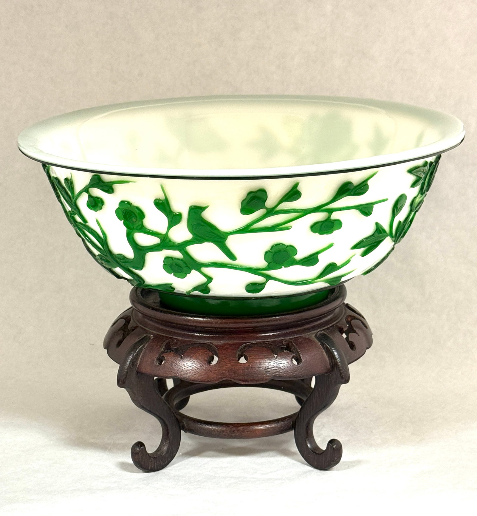 Pekin Cameo Glass Bowl: Large Pekin white cameo glass bowl with stylized green flowers and birds on wooden stand; ht. on stand 8 3/4". PROVENANCE: Carol Lange, granddaughter of William Davidson founder of Harley Davidson.
