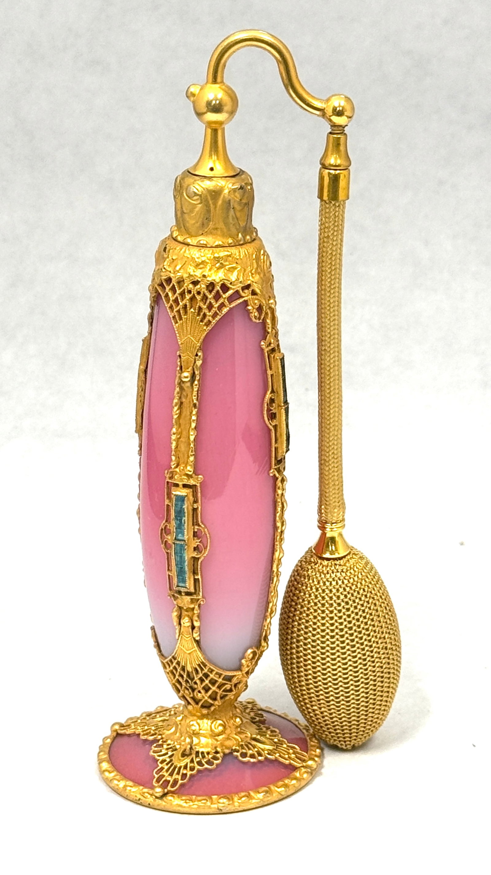 DeVilbiss Imperial Perfume: DeVilbiss Imperial Line Perfume Atomizer in Peachblow framed with a metal filigree cage with blue jewels, signed DeVilbiss, 8" ht. CONDITION: no chips, cracks, repairs, or material defects found,