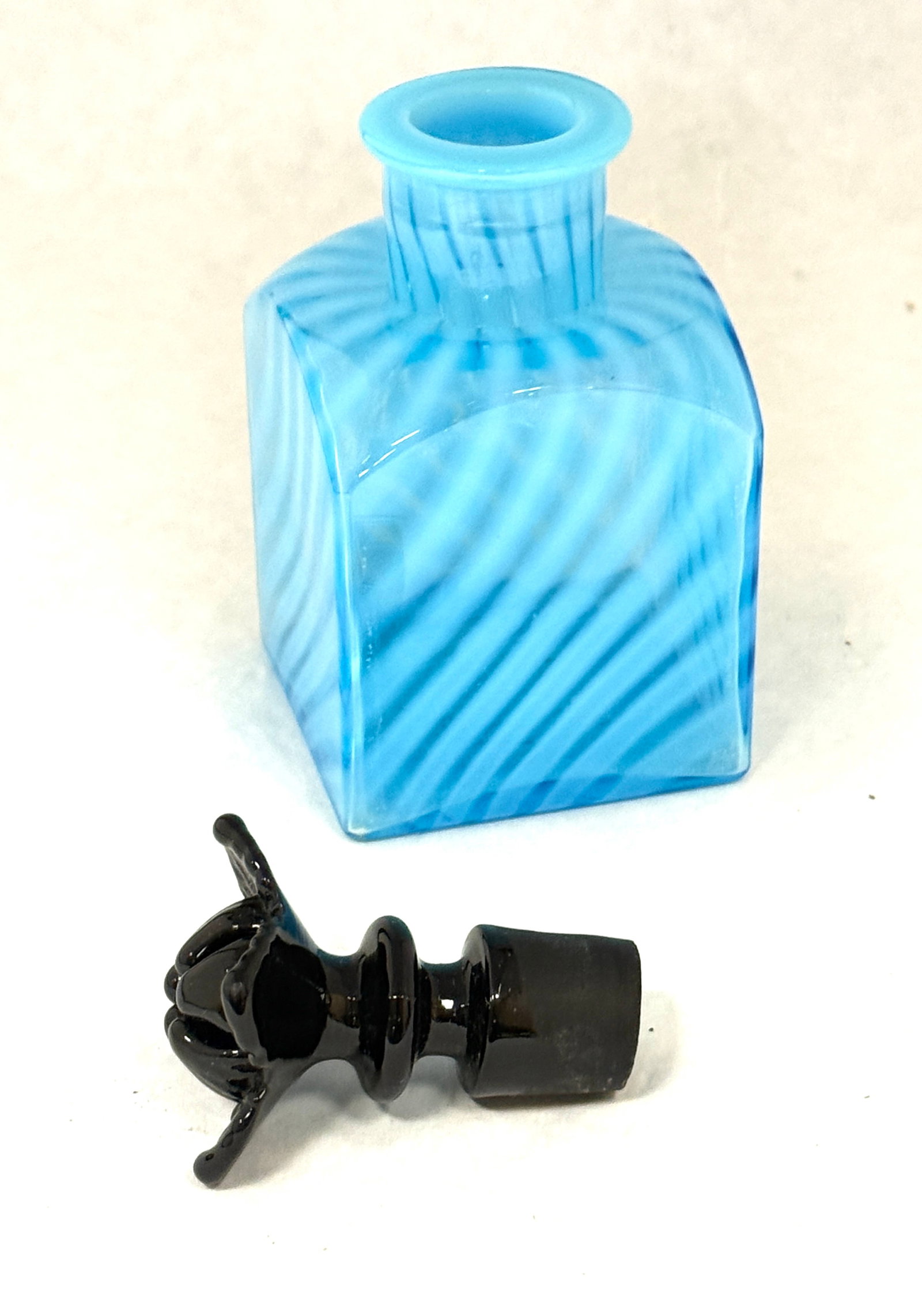 Fenton Blue Opalescent Cologne: Fenton blue opalescent cologne bottle with a black flower stopper, 5 1/2" ht. CONDITION: no chips, cracks, repairs, or material defects found, Jaremos attempts to call any material flaw that affects