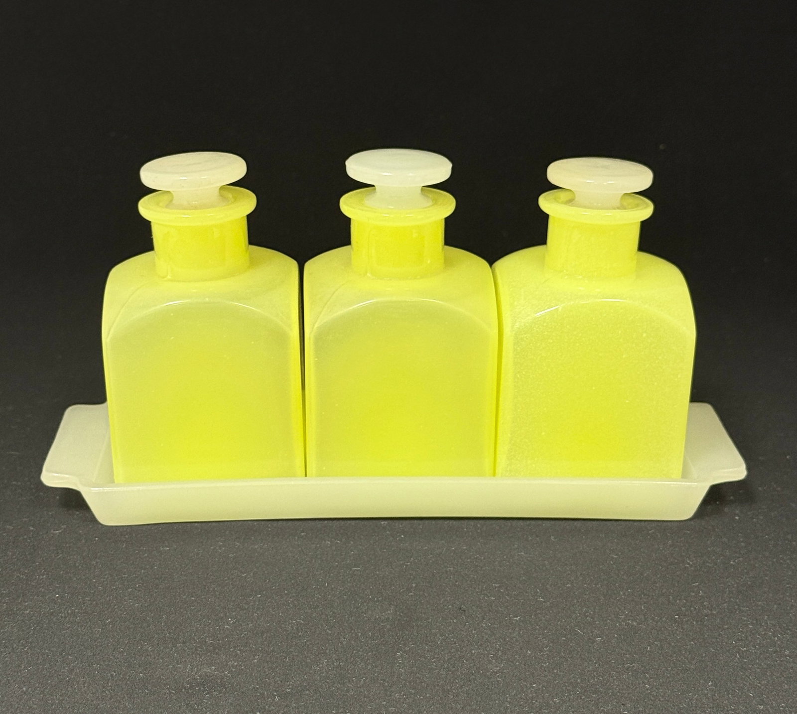 Fenton 3 Bottle Bath Set: Fenton Vaseline three bottle bath set and tray, 9 1/2" long. CONDITION: no chips, cracks, repairs, or material defects found, Jaremos attempts to call any material flaw that affects the price, but