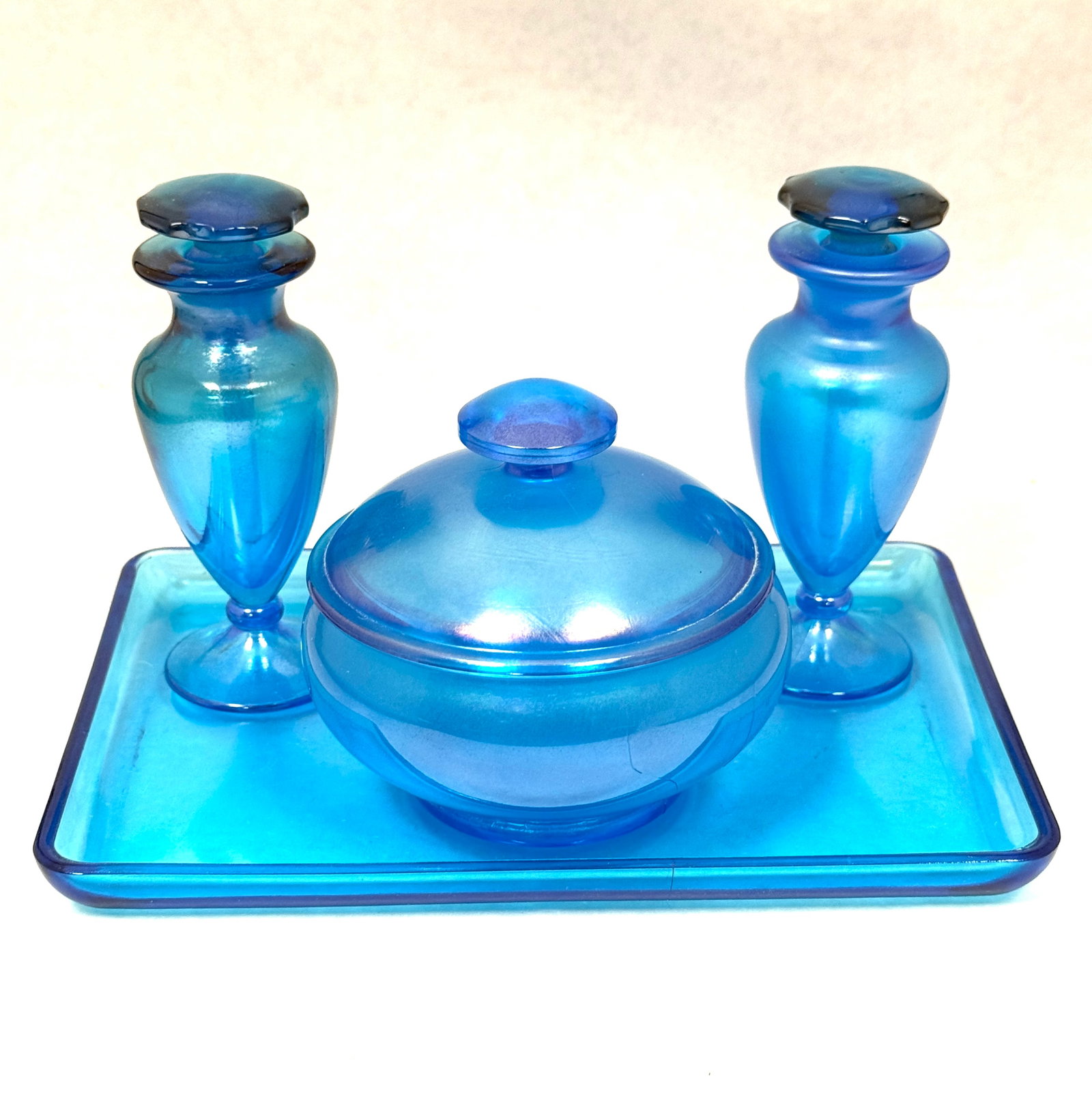 Fenton Blue Stretch Bath Set: Fenton Blue stretch glass bath set consisting of two perfume bottles a jar and tray, 8 1/2" long. CONDITION: no chips, cracks, repairs, or material defects found, Jaremos attempts to call any