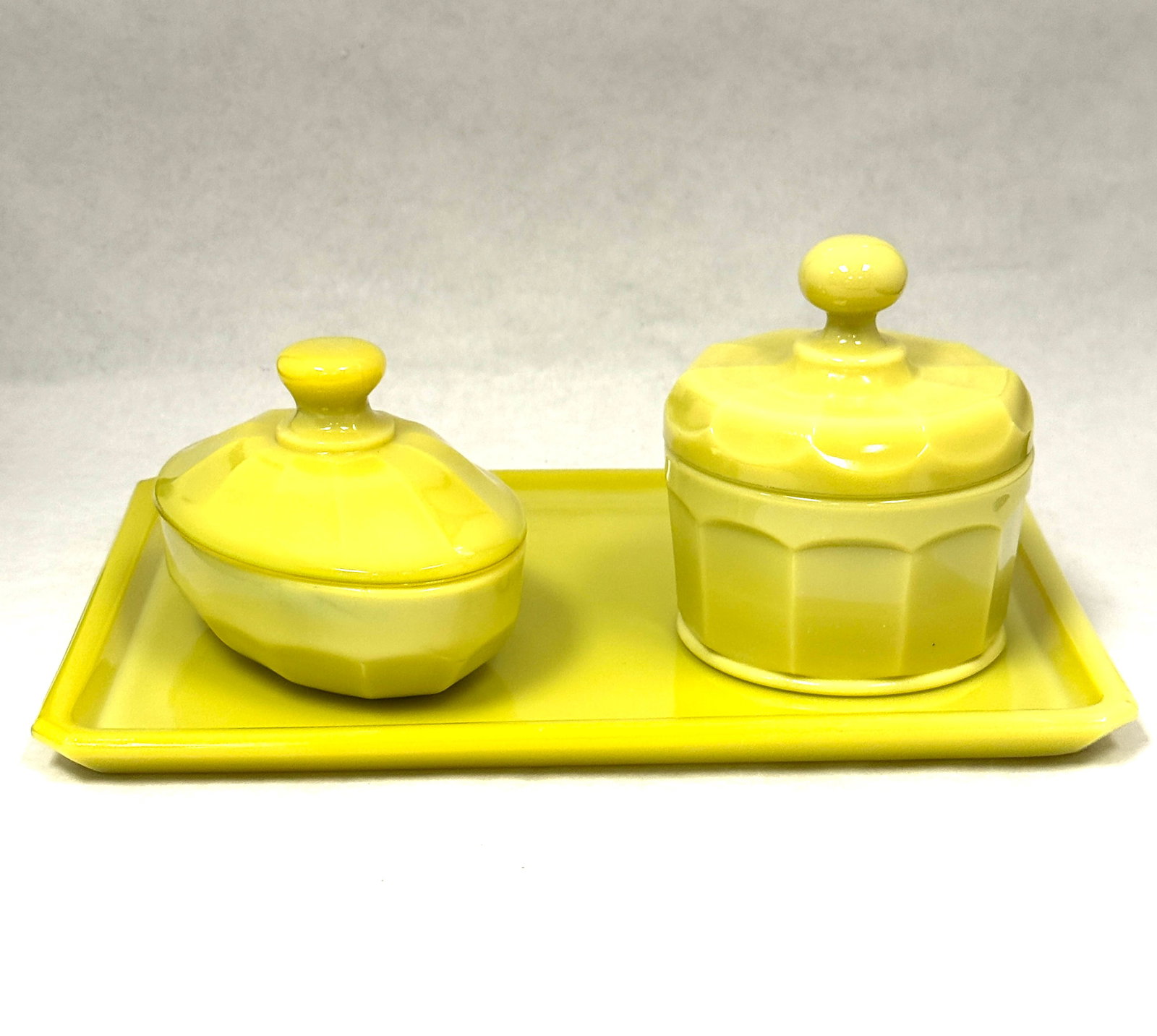 Cambridge Yellow Agate Bath Set: Cambridge yellow/vaseline agate bath set including two covered jars and a tray, uranium base glass, tray 11 1/4" long. CONDITION: chip to the interior of one jar.