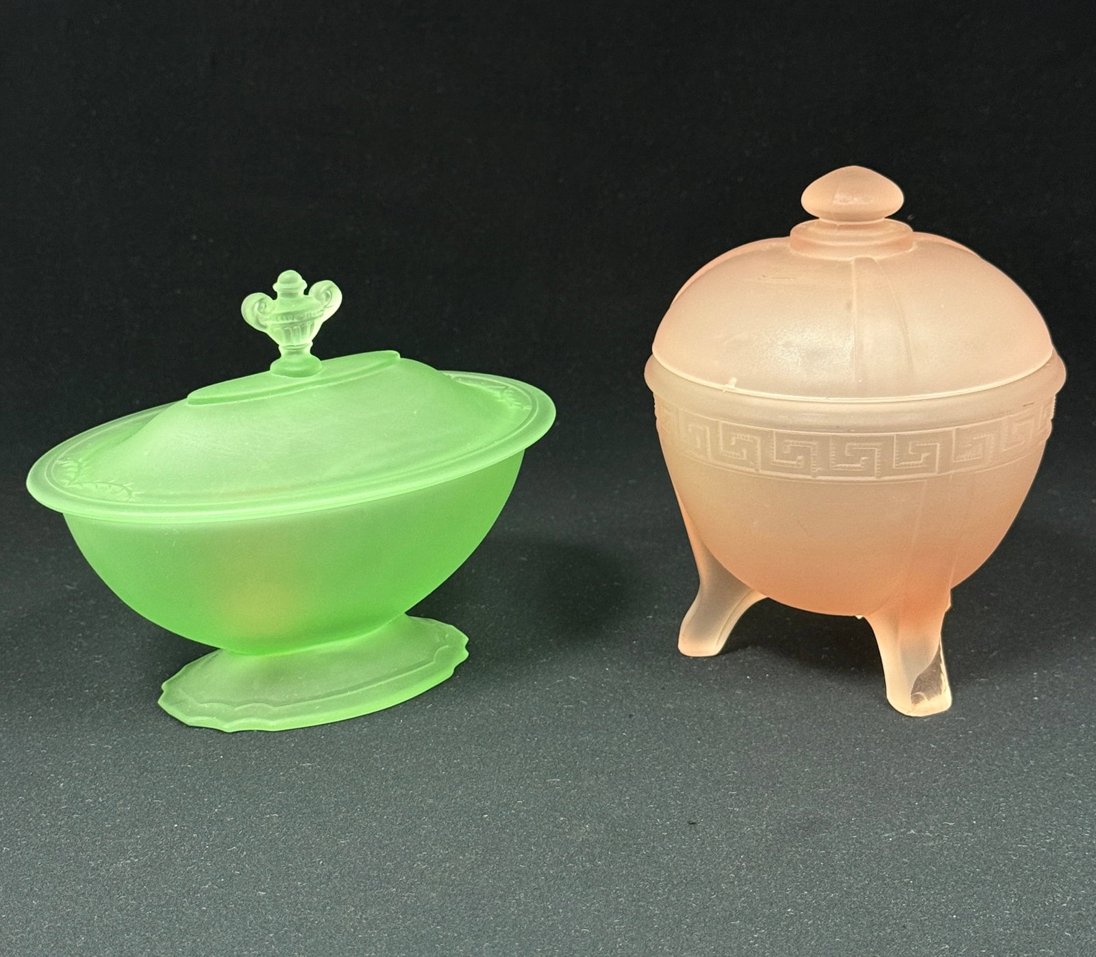 Two Taussaunt Bathroom Boxes: Two Taussaunt bathroom boxes including a Peach Greek Key together with a Vaseline ovoid with urn finial, tallest 5 1/2" ht. CONDITION: chip to the foot of the Greek Key