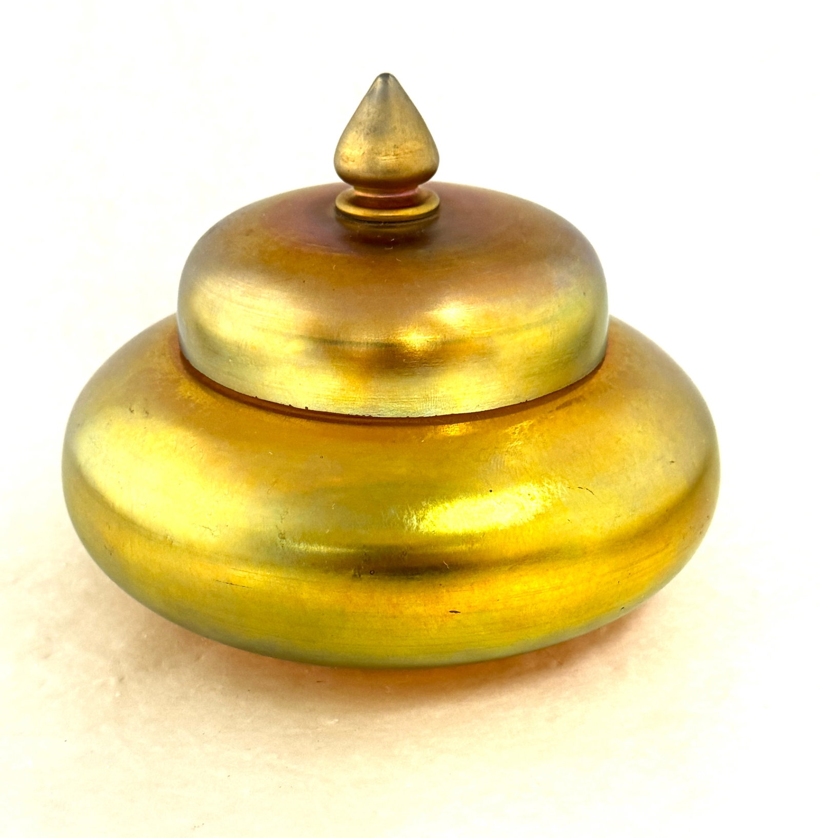 Steuben Gold Aurene Box: Steuben gold aurene dresser box with a pointed finial, signed Aurene 2948, 6" wide. CONDITION: no chips, cracks, repairs or material defects found, Jaremos attempts to call any material flaw that