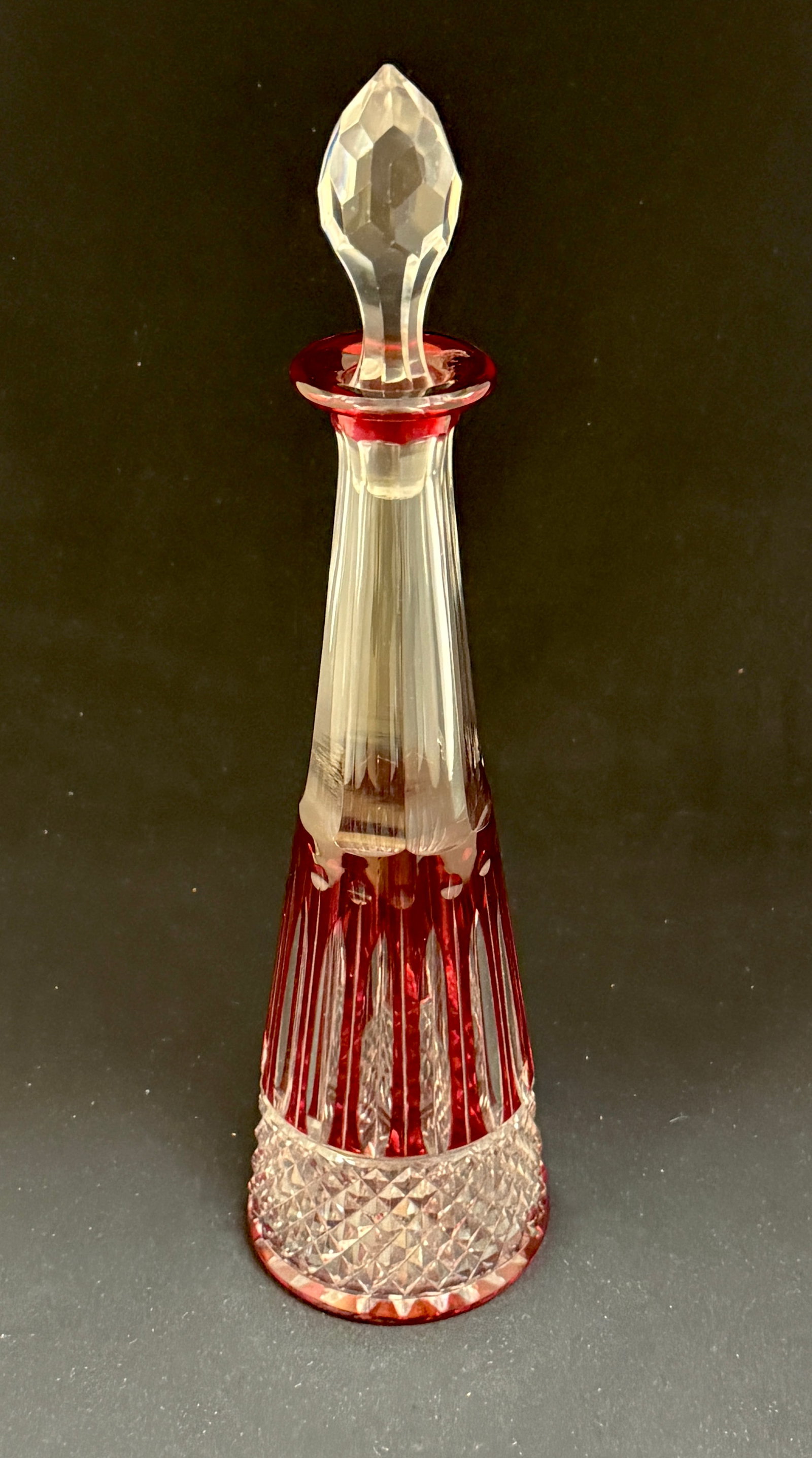 St Louis Cut to Clear Bottle: Reverse Tee Pee cut to clear cranberry bottle with faceted stopper, signed St Louis France; ht. 12". CONDITION: no chips, cracks, repairs or material defects found, Jaremos attempts to call any