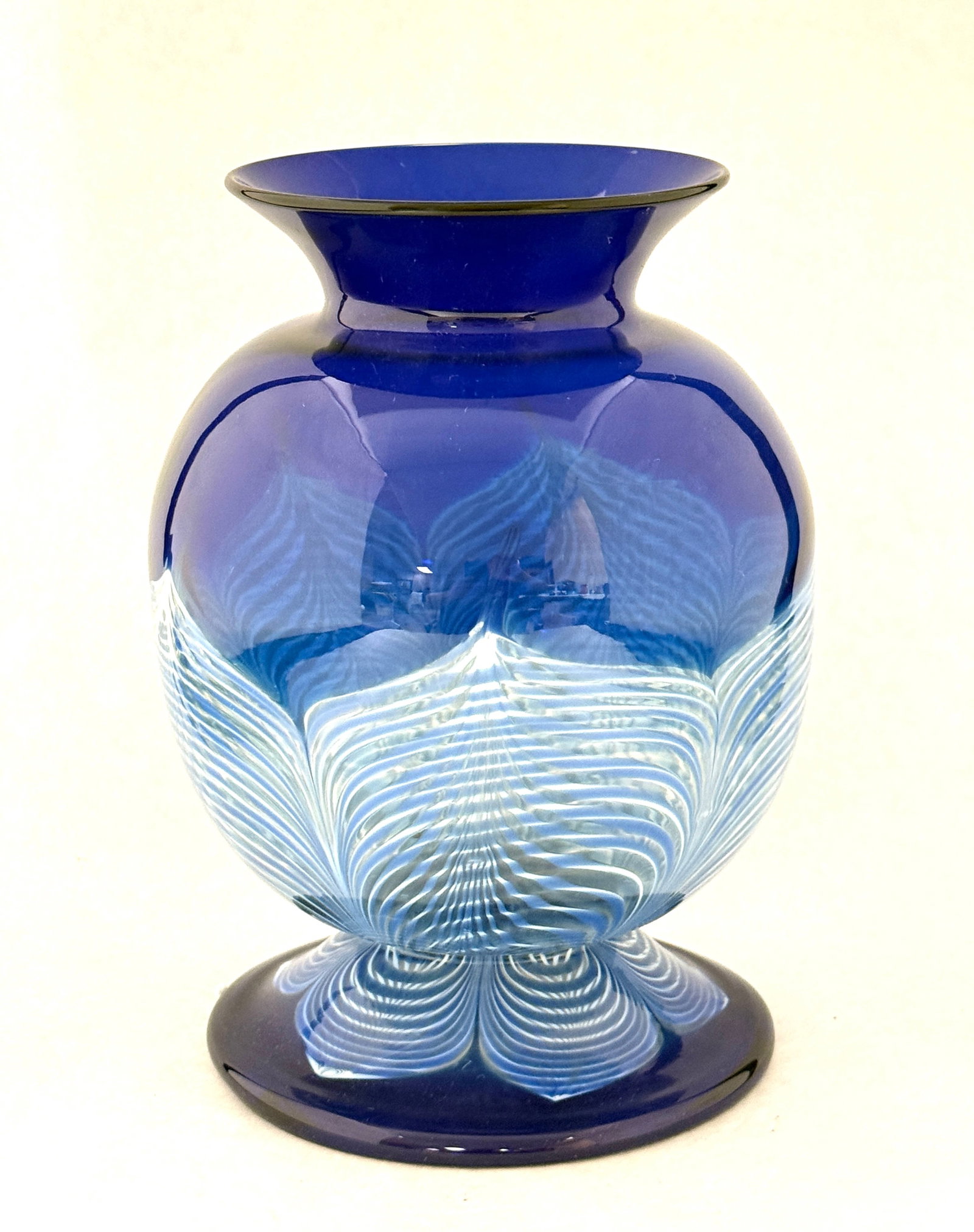 Translucent Durand Glass Vase: Durand translucent footed urn form vase decorated with blue pulled feathers, 8 1/2" ht. CONDITION: no chips, cracks, repairs or material defects found, Jaremos attempts to call any material flaw that 