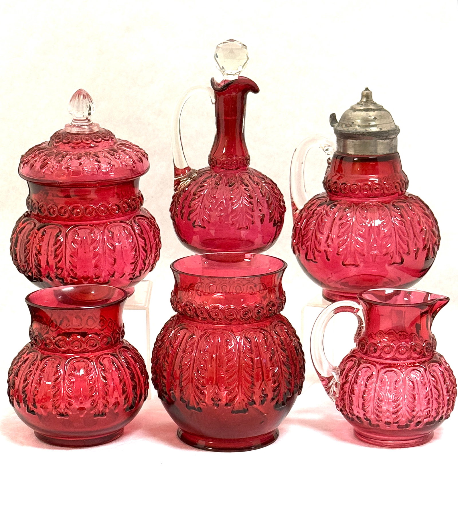 6 Northwood Leaf Umbrella Items: 6 Northwood cranberry Leaf Umbrella items including a syrup, a cruet, covered sugar, creamer, waste, and celery; tallest 7". CONDITION: no chips, cracks, repairs or material defects found, Jaremos
