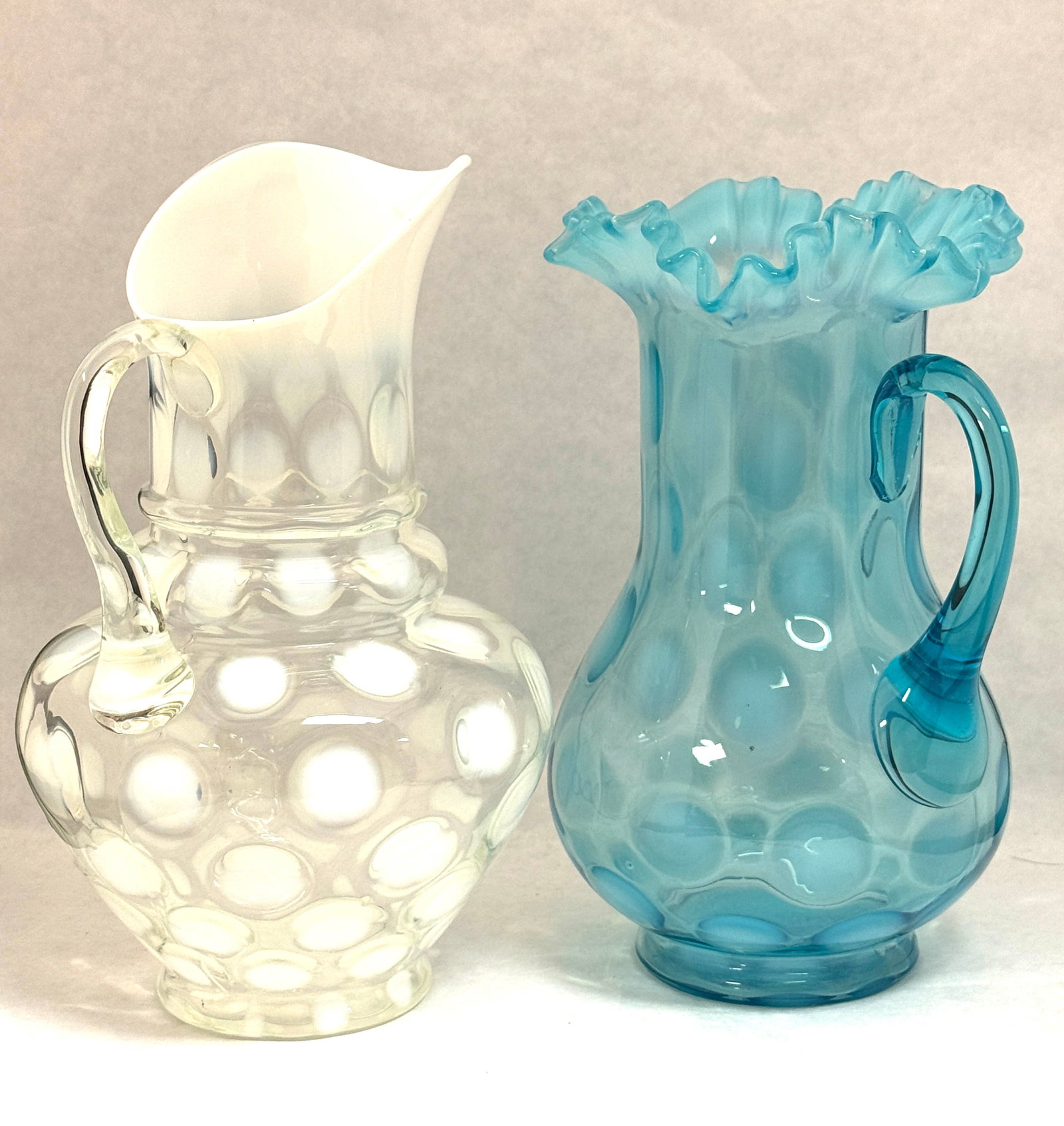 2 Coinspot Opalescent Pitchers: 2 coin spot opalescent pitchers one blue and one white; ht. 10 1/2". CONDITION: no chips, cracks, repairs or material defects found, Jaremos attempts to call any material flaw that affects the price, 