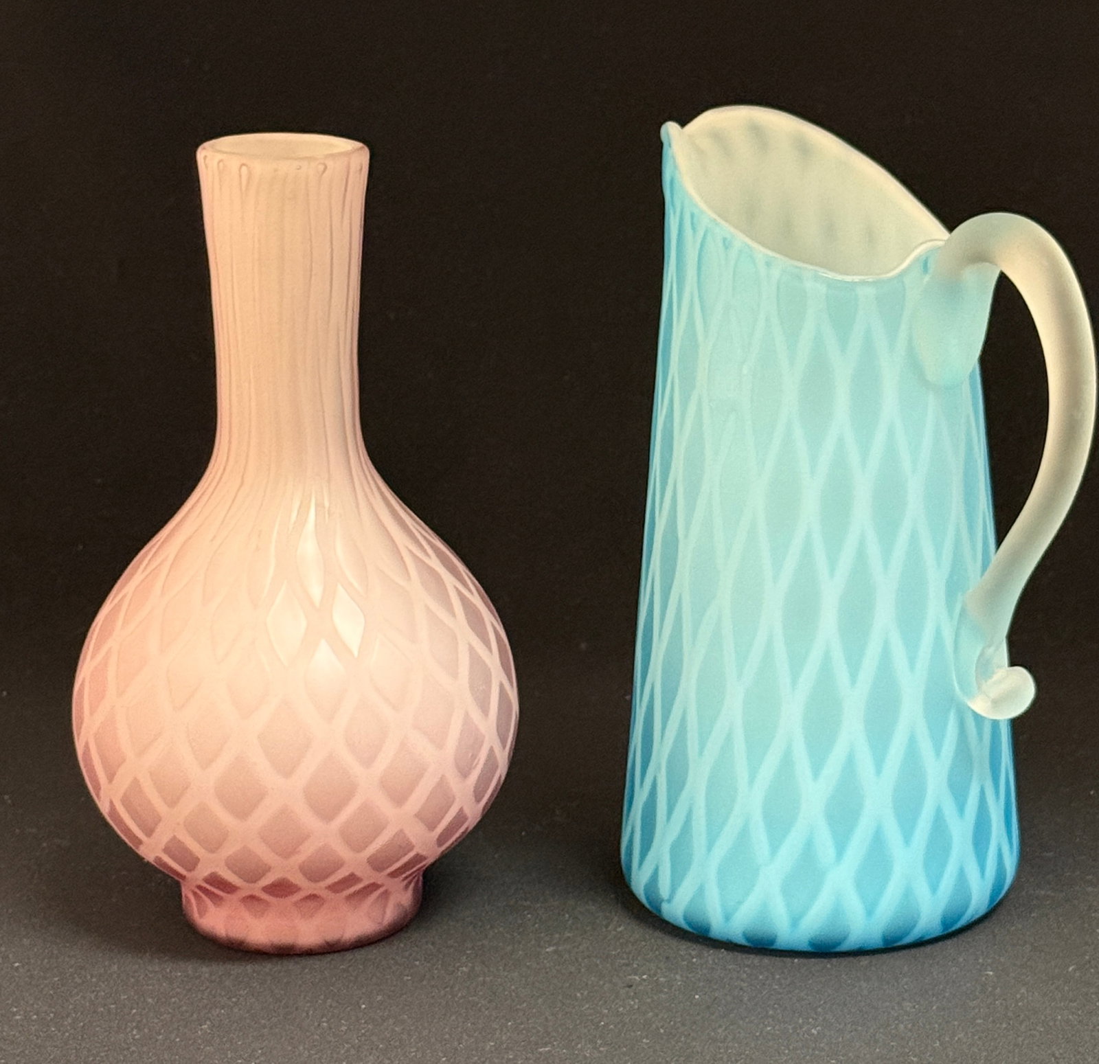 Two MOP DQ Glass Items: Two Mother of Pearl diamond quilted glass items including a blue pitcher and a pink bulbous vase, 7 1/2" ht. CONDITION: no chips, cracks, repairs, or material defects found, Jaremos attempts to call