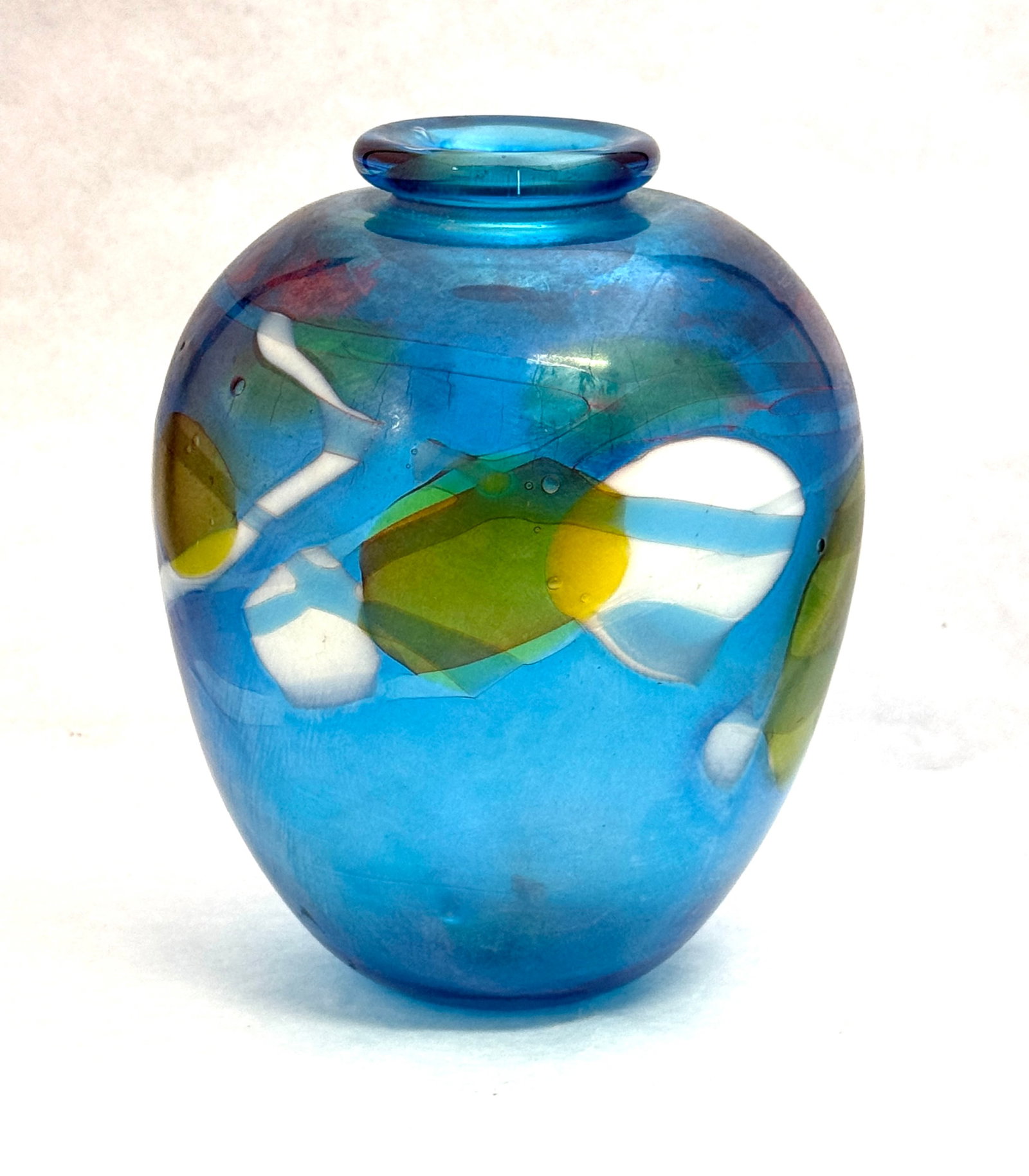 Tom McGlaughlin Glass Vase: Tom McGlaughlin blue glass vase with yellow and white striated moons accented with splashes of red, signed Tom McGlaughlin 1976, 7 1/2" ht. CONDITION: no chips, cracks, repairs, or material defects fo