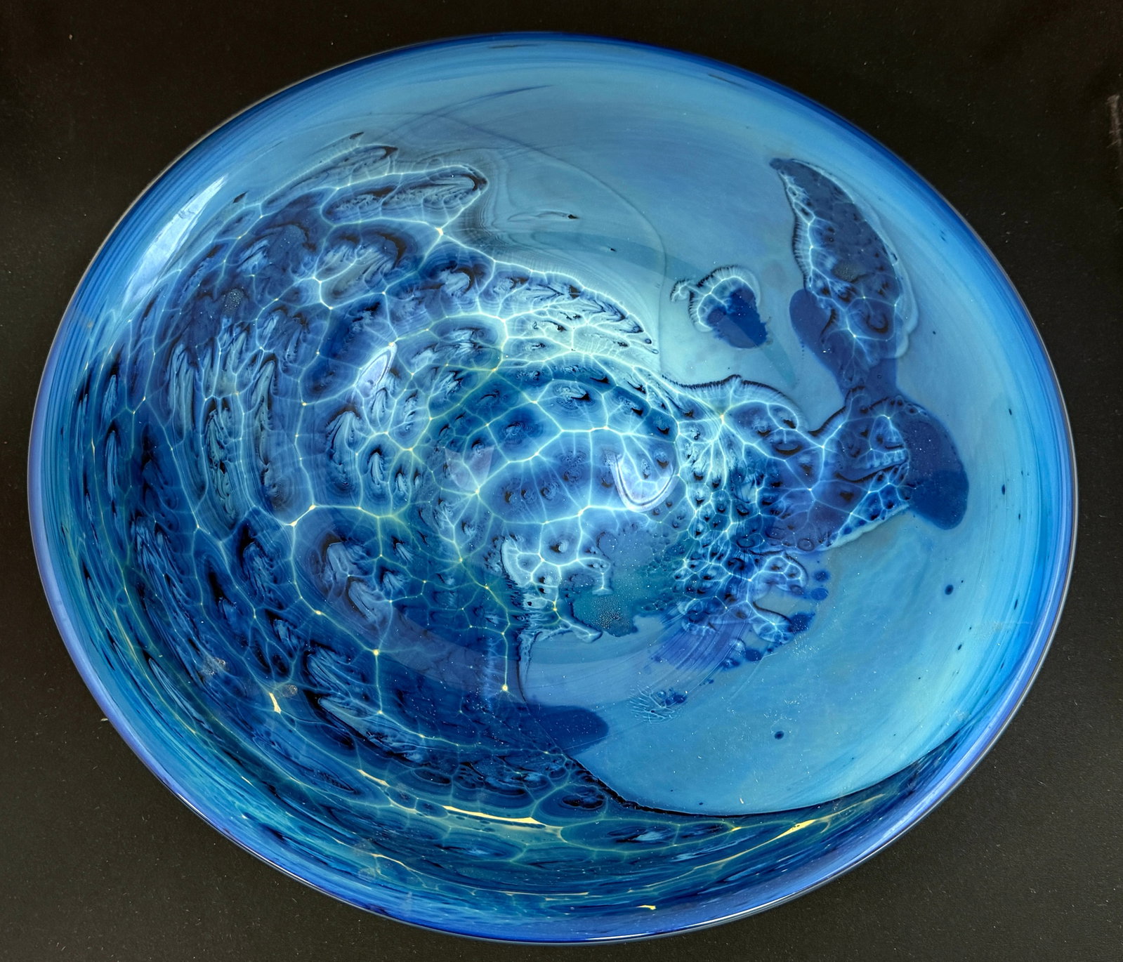 Large Josh Simpson Center Bowl: Large blue Josh Simpson center bowl in a cloud design, signed Simpson 2000, 16" wide. CONDITION: no chips, cracks, repairs, or material defects found, Jaremos attempts to call any material flaw that