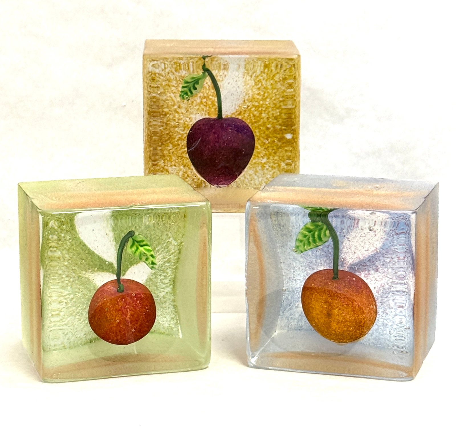 Stephanie Trenchard Glass Blocks: Three Stephanie Trenchard glass blocks decorated with internal fruit, each signed, Trenchard 2007, 4 1/2" ht. CONDITION: no chips, cracks, repairs, or material defects found, Jaremos attempts to call