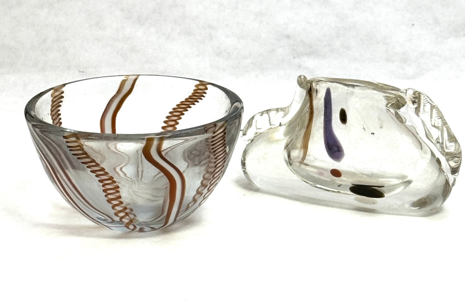 Two Cabinet Art Glass items: Two cabinet art glass items including a free form Rhyes Williams vase together with an Alan Goldfarb ribbon bowl, largest 3" ht. CONDITION: no chips, cracks, repairs, or material defects found,
