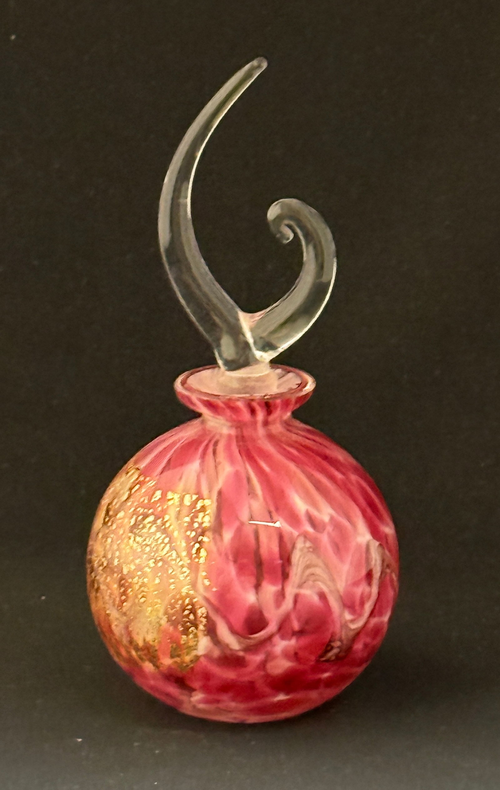 Pink Art Glass Perfume Bottle: Pink art glass perfume with gold splatter in a square, no signature; ht. 7" with dopper. CONDITION: no chips, cracks, repairs, or material defects found, Jaremos attempts to call any material flaw tha
