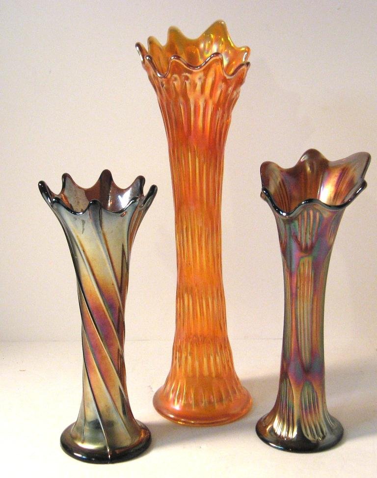 Three large Carnival swung vases,: Including a large Fenton "April Shower" in rich marigold, a Fenton amethyst "Diamond and Ribbing," and a Spiralex attributed to Dugan, tallest 15 1/2" ht.