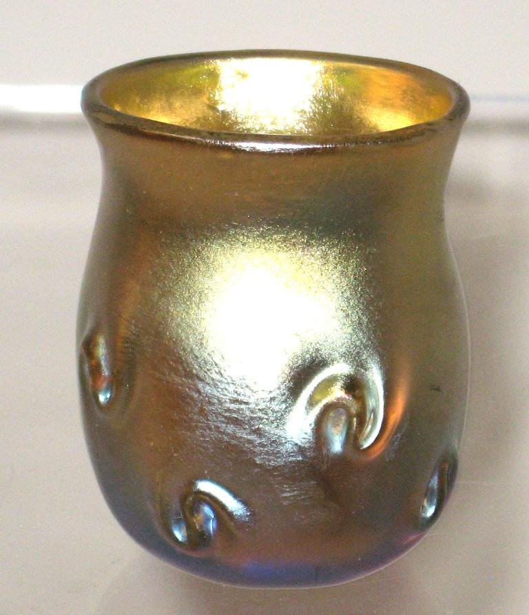 Tiffany gold Favrile shot glass cordial,: cylindrical form in iridescent gold glass decorated with pig tail prunts, signed T5586 L. C. T. 2" ht.
