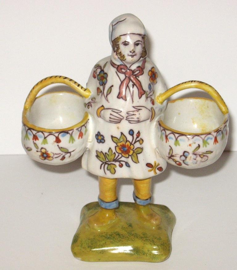 Desvres faience Breton figural double salt,: holding two handled baskets, wearing hat and decorated with Rouen and sponged decor. Marked "Rouen." 5 3/4" ht. c.1910