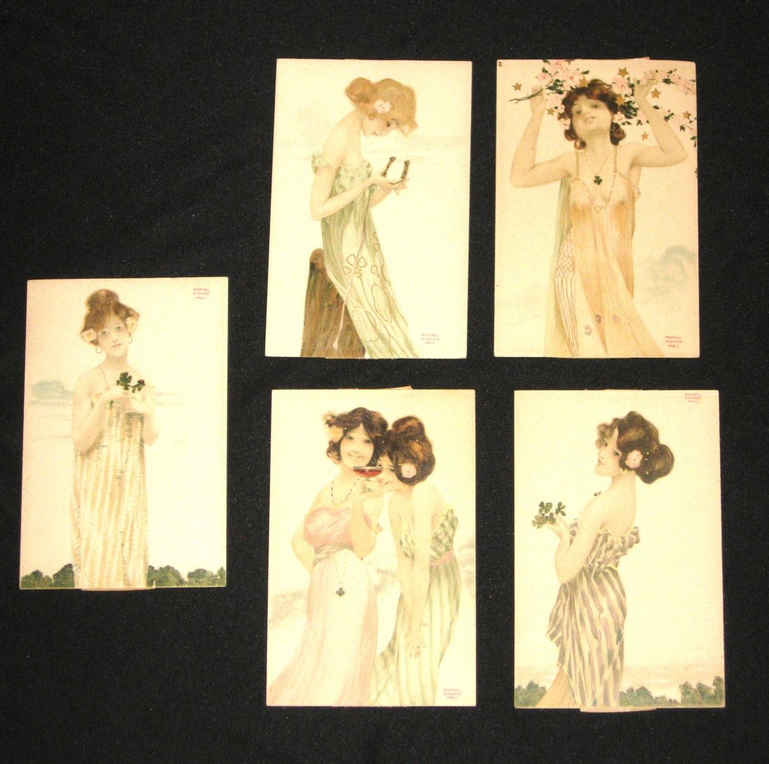 Five Raphael Kirchner postcards,: Art Nouveau cards of young ladies in pastel and gold highlighted dresses, each marked Raphael Kirchner Paris, back with multi language names for Postcards, 3 1/2" by 5 1/2".