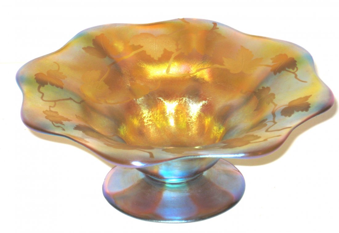 Tiffany gold Favrile glass compote,: footed scalloped rim decorated with an intaglio grape vine, excellent color, signed 1865 L. C. Tiffany-Favrile and carries a paper label, 7" wide.