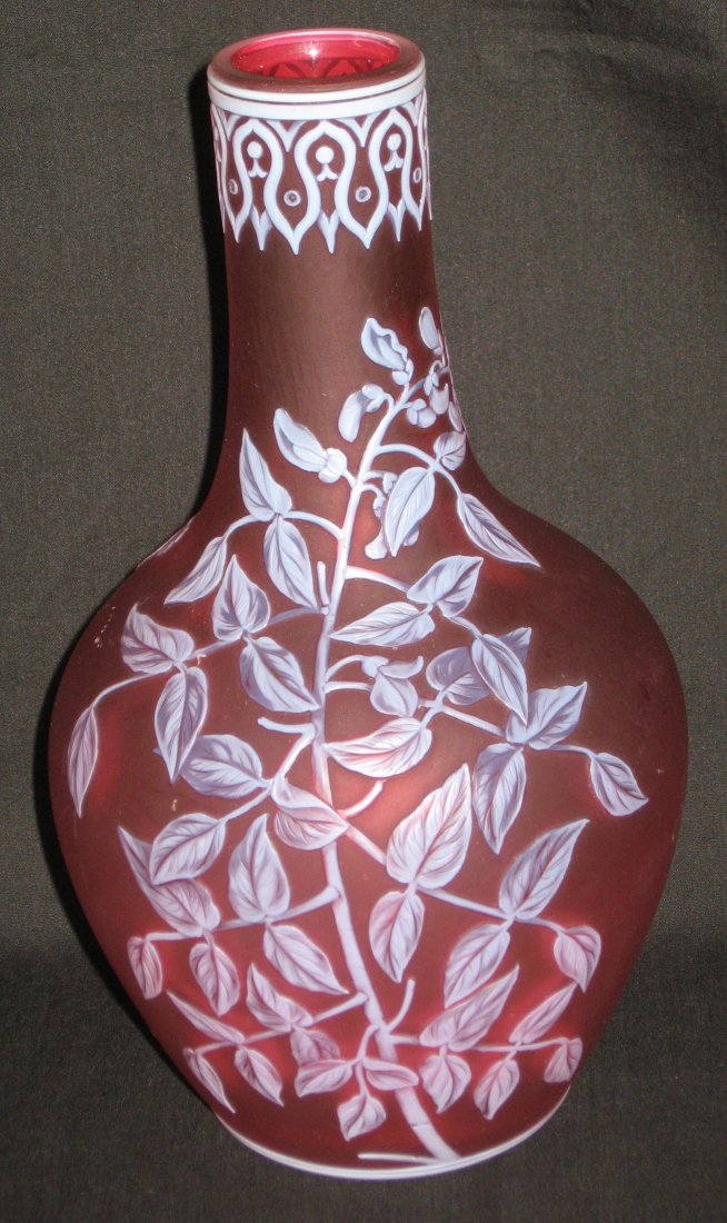 Webb red English cameo glass vase,: bulbous stick form in frosted red glass decorated with an elongated leafy stemmed flower and butterfly on reverse, the rim with an intricate Moorish design, 8 1/4" ht.