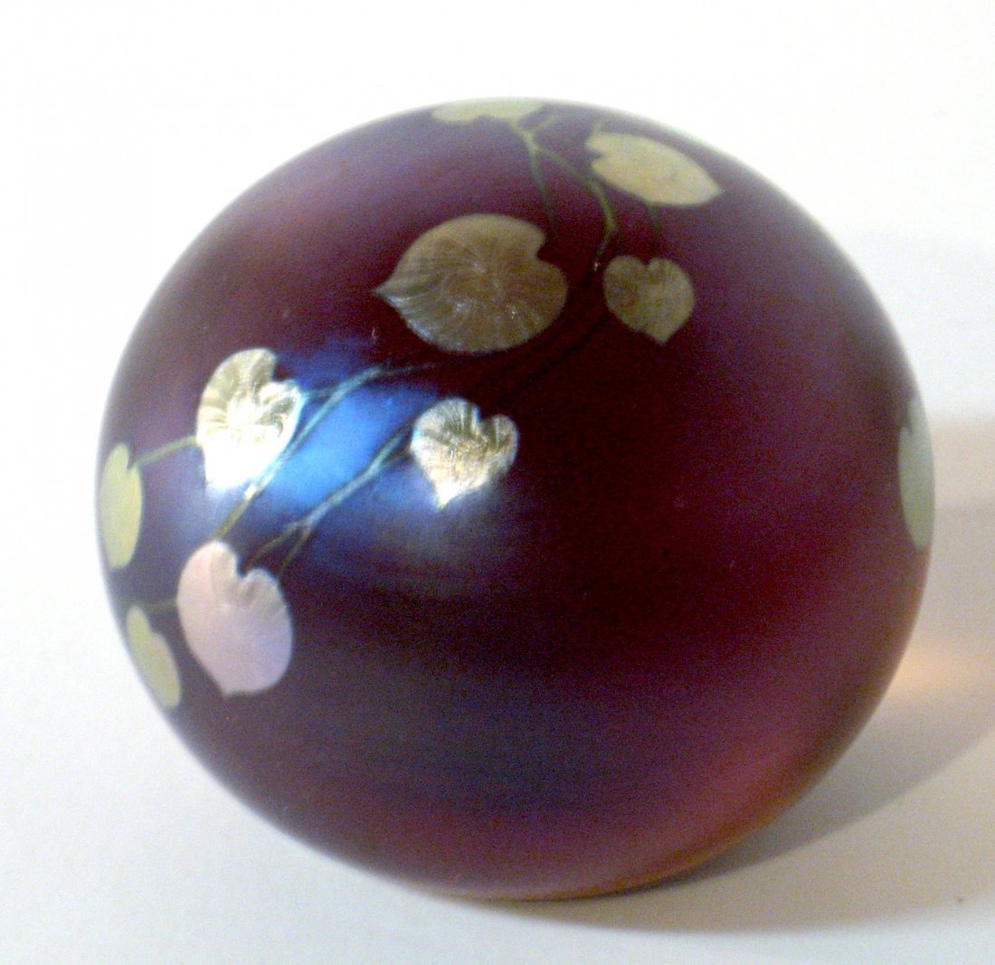 Daniel Salazar glass paperweight,: Deep Rose Amber decorated with a silver blue heart and vine, marked D Salazar L S 86, 2 1/2" wide. NOTE: Daniel Salazar has been a flagship artist at Lundberg Studios and in his own right.