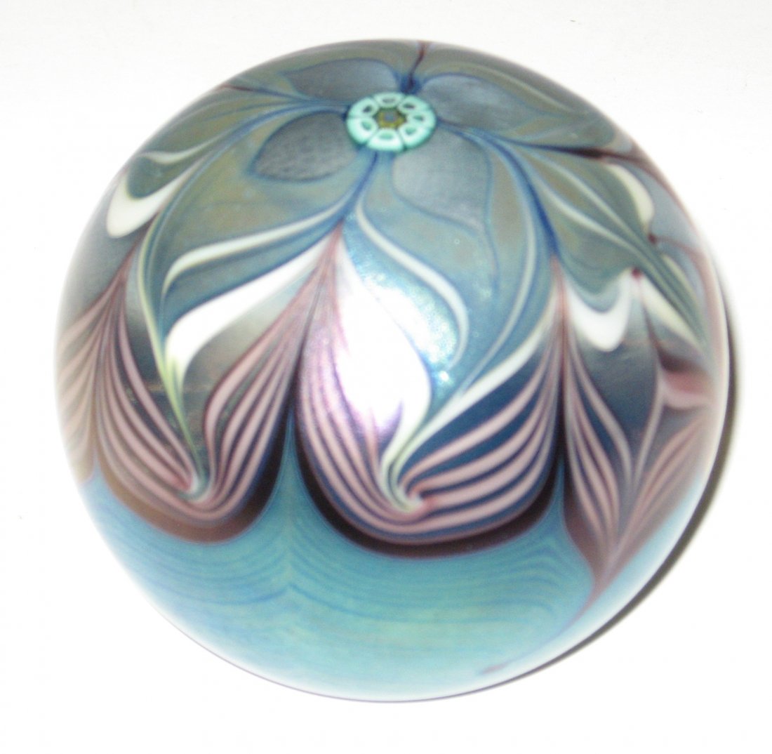 Orient and Flume glass paperweight,: Iridescent blue decorated with a purple hooked feather and a central Millefiori with a star, signed Orient and Flume 1978, 3" wide.