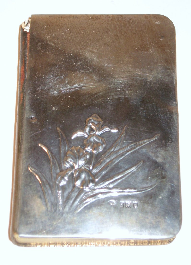 Sterling covered Common book of prayer,: The Church of England "The Book of Common Prayer" with a Sterling front cover with embossed stemmed Iris, marked WC for William Comyns and Sons, 4 3/4" by 3" wide.