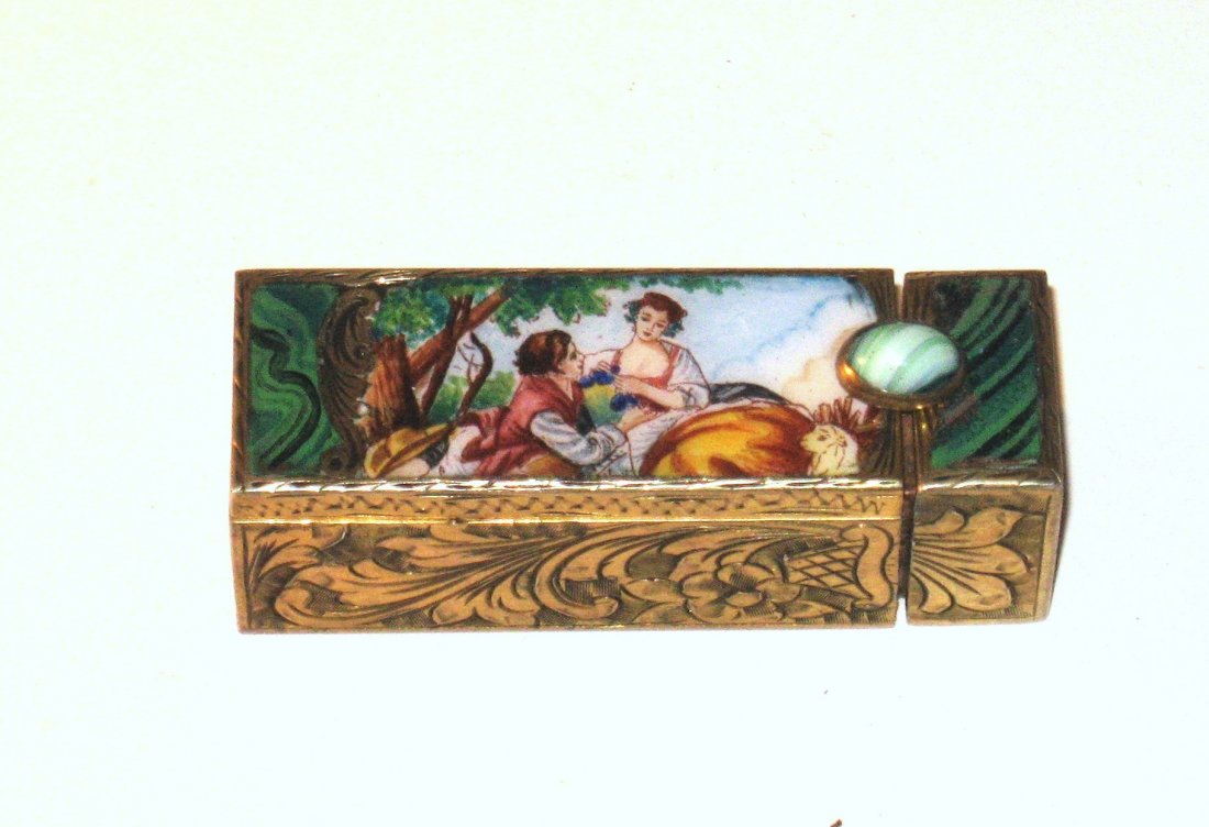 Unique Viennese enameled lip stick,: rectangular form in an embossed gold tone metal decorated with an enameled scene of a courting couple on the front, agate jeweled latch, 2 1/4" long.