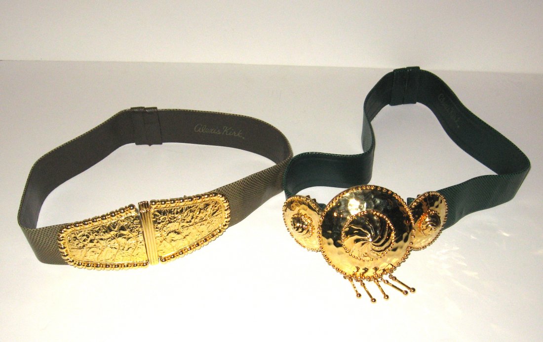 Two Alexis Kirk snake skin adjustable belts,: Including a gray with large gold tone buckle expandable to a 34 waist, together with a green snake skin leather belt with a triple gold tone buckle expandable to a 34" waist. Belts would fit any size