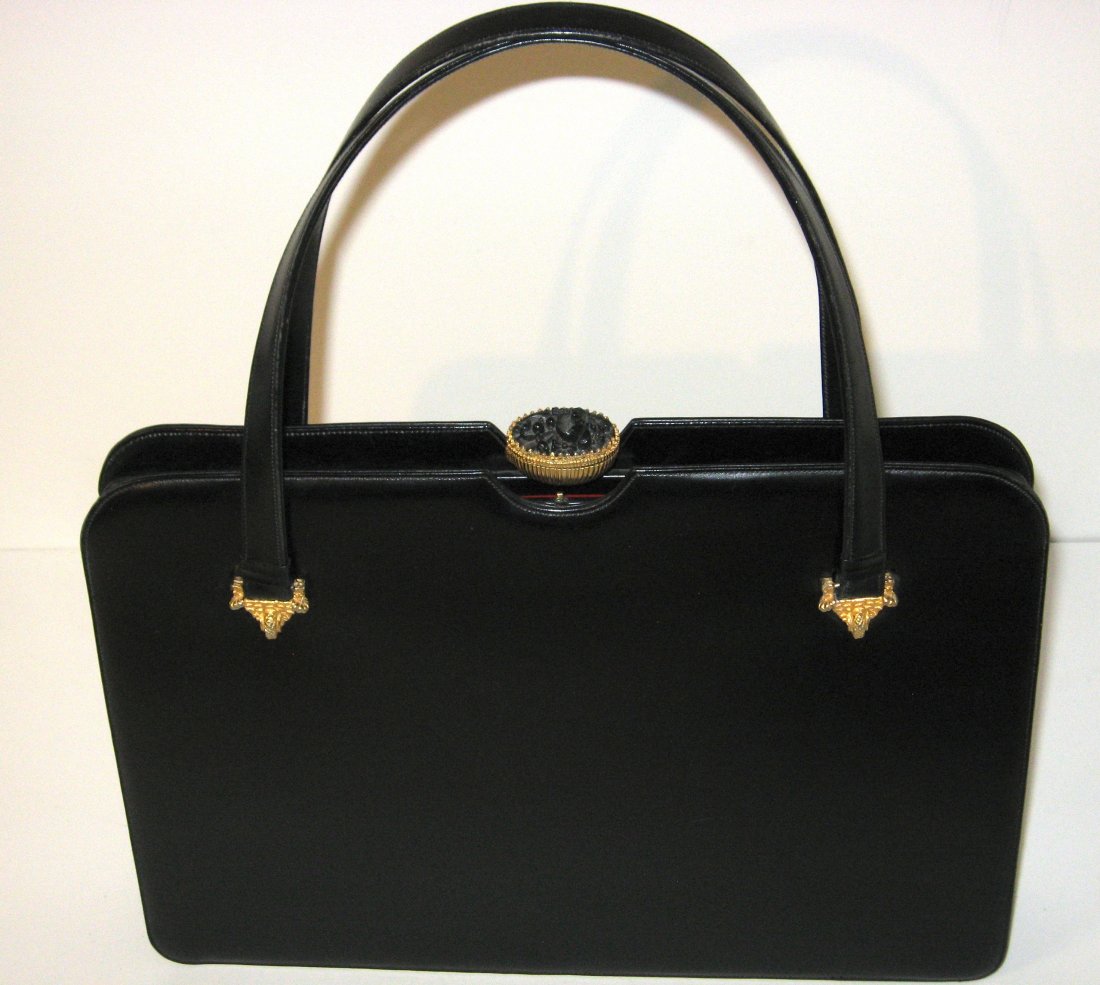 Rare Dorian leather purse with hidden snuff box,: Black leather Dorian purse with red interior and change purse, adorned with a gilt and black flower jeweled clasp with hidden snuff box, 14" long by 10" ht.