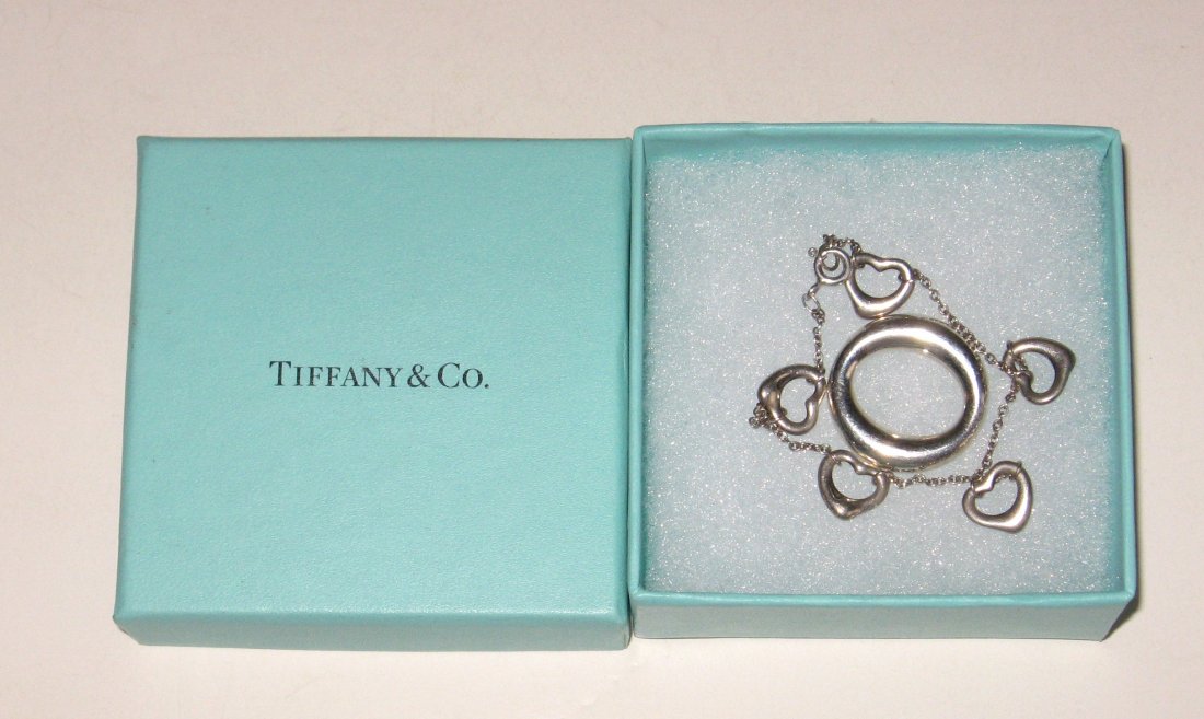 Two Tiffany sterling silver jewelry items: Including a bracelet with diminutive hearts signed Tiffany & Co. Elsa Peretti 925 Spain, together with a sterling O marked Tiffany & Co. Elsa Peretti 925 Spain, comes with original turquoise box.