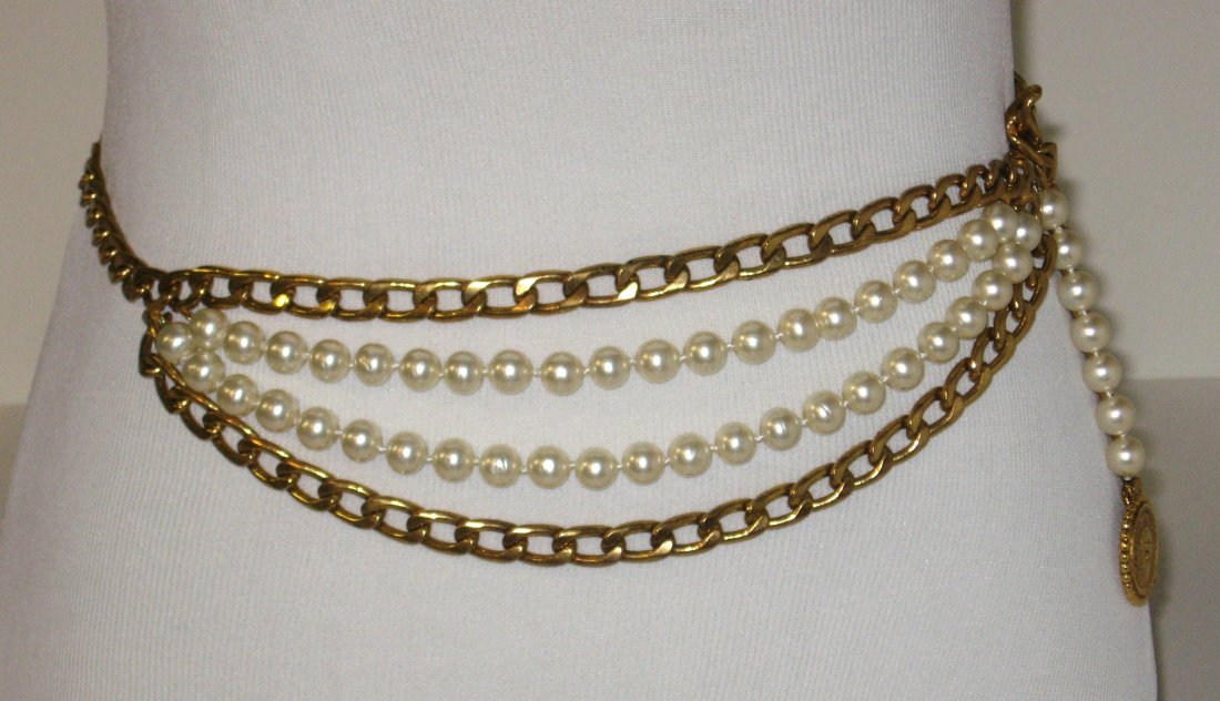 Chanel gold tone belt: double branch of gold tone chains and faux pearls with company coin medallion with picture or Coco Channel and reverse with double CC. Will comfortably fit waist 22-34.