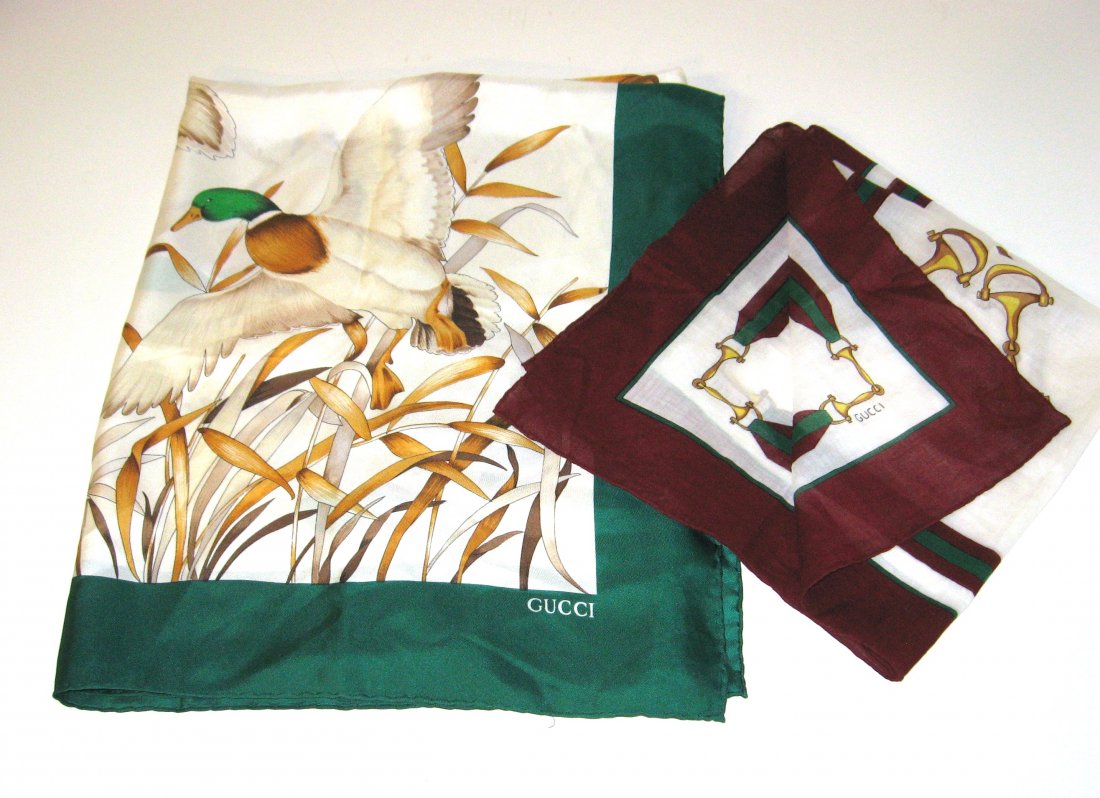 Two Gucci scarves,: Including a Silk scarf with green border with ducks, 34 by 34, together with a small cotton handkerchief form with a crimson border adorned with stirrups, 22 by 22, both marked Gucci