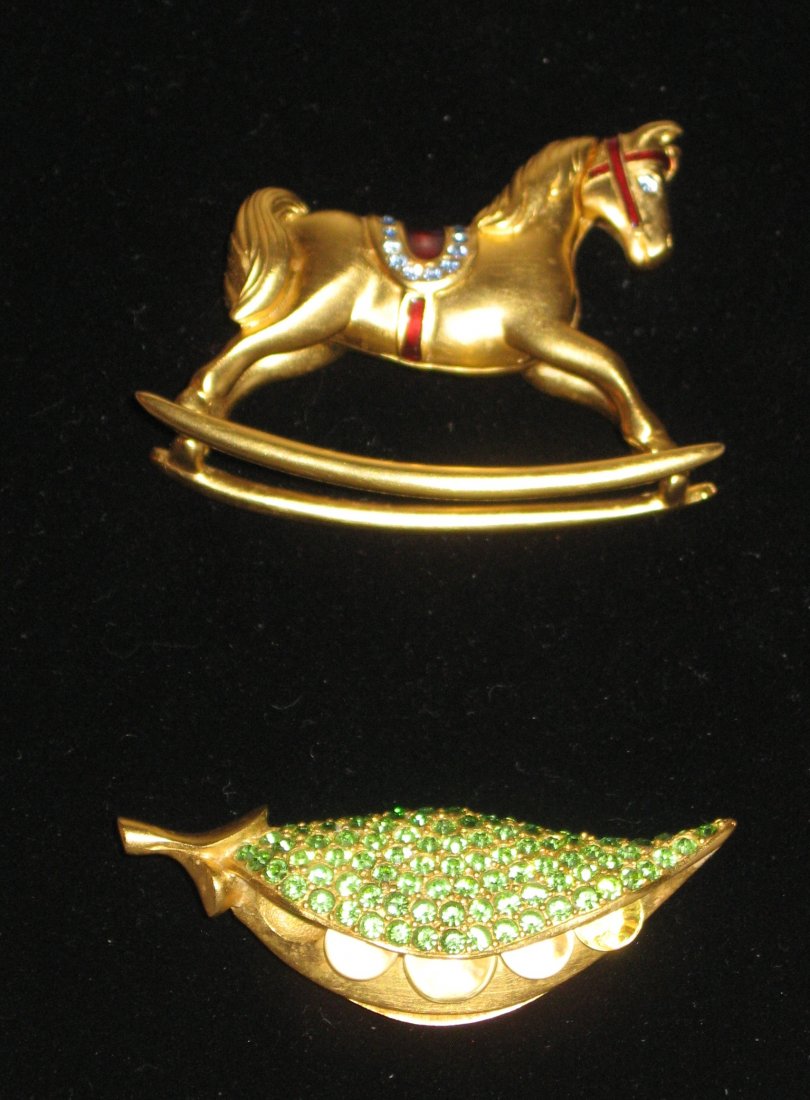 Two figural Estee Lauder compacts.: Including a gold tone horse with a red and blue jeweled saddle, together with a green crystal pea pod, both marked and still have perfume.