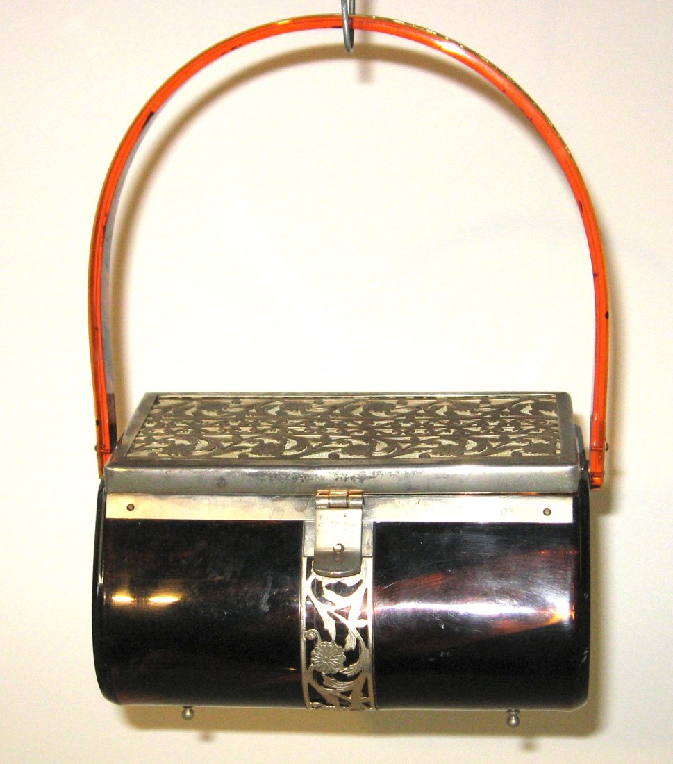 Lucite and metal purse,: Post War Modernism amber Lucite bag with a metal mesh scrolling lid, marked on the interior Tyroline New York, without handle 7" long by 4" ht.