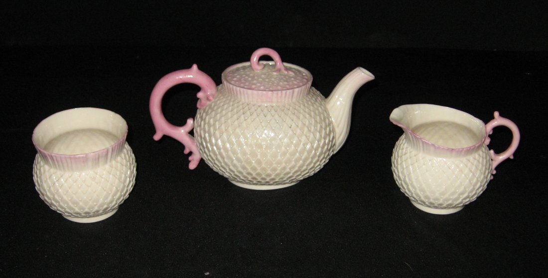 Rare Belleek "Thistle" pattern tea set,: Thistle Dejeuner set including a tea pot, sugar and cream pitcher each with pink highlighted rims, 1st black mark, tea pot 8" long. LITERATURE: "Belleek The Complete Collector's Guide" by Degenhardt s