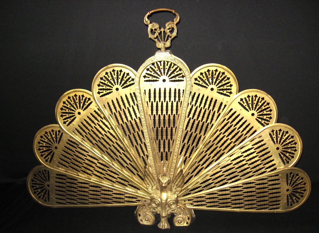 Period brass fireplace screen,: Pierced Moorish designed screen which folds up into an embossed frame with a Griffin foot on front and back, 27" ht. 39" wide when open.