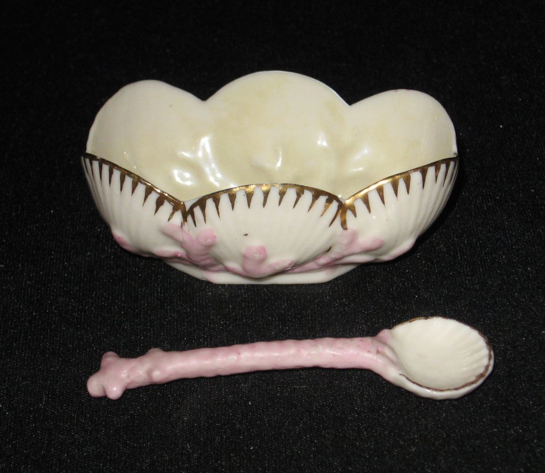 Belleek "Cleary" salt cellar and spoon,: Oblong form with pink coral together with a pink coral spoon, 2nd black mark, 3" long.