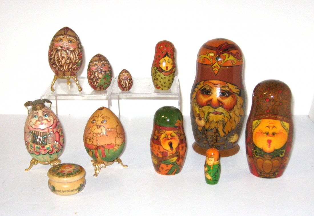 Five Russian folk art items,: Including two cartoon fanciful eggs on gold stands, an oval wood pill box with flower, a three egg set of Santa, and a lacquer doll set of Saint Nicolas, tallest 7" ht.
