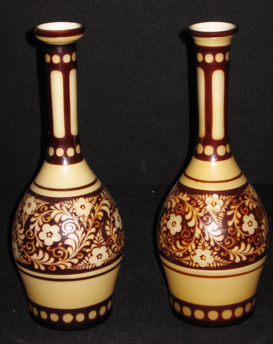 Pair of Leopold Palda intaglio bottles,: Crimson over cream bottles with a flower scrolling design, marked with a paper label Famosa LPW Made in Austria, 10 1/2" ht.